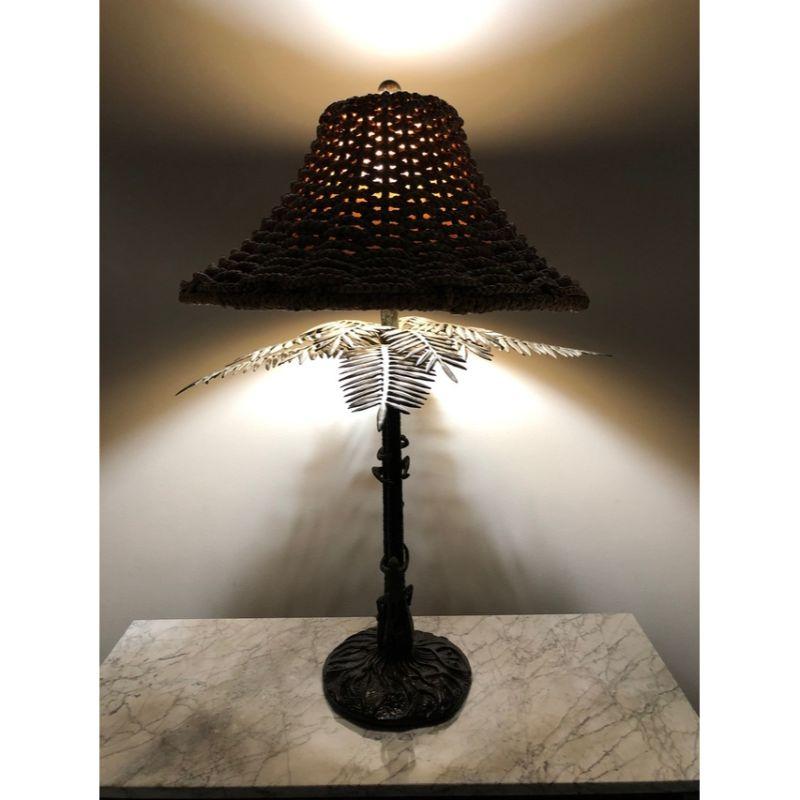 A tropical themed lamp by Maitland Smith. Handmade in the Philippines likely in the late 20th Century. Palm Tree with bronze fronds and monkeys. Single standard bulb socket with toggle switch on cord. Includes rattan shade.

Measures: 24W 24D 35H,