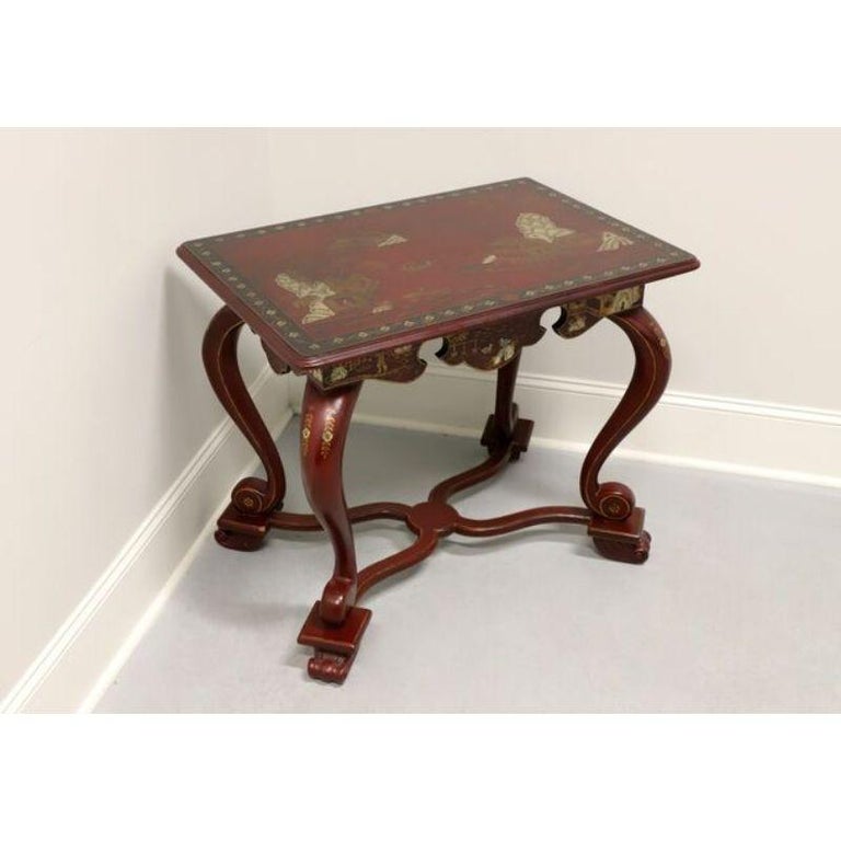 An Asian inspired accent table by Maitland Smith. Solid wood hand painted overall red with Chinoiserie details of gold, black and white on top, apron and legs. Features a banded top, carved apron, cabriole legs and curved feet resting on a curved
