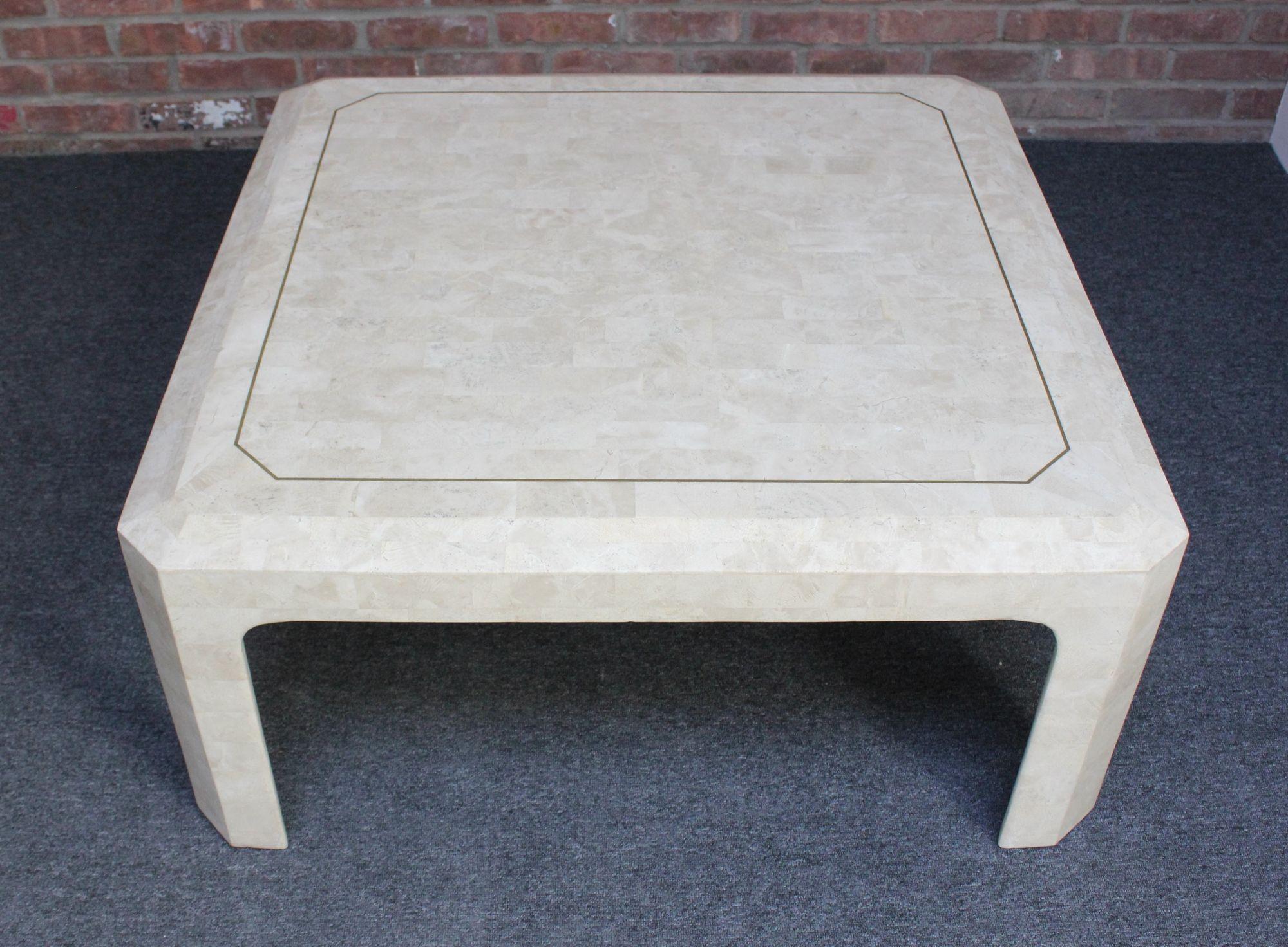 Attractive square coffee/cocktail table in beige tessellated fossil stone with brass inlay border and beveled edge by Maitland-Smith (ca. 1970s, Philippines).
Very good, vintage condition with scratches/light wear naturally occurring in the stone