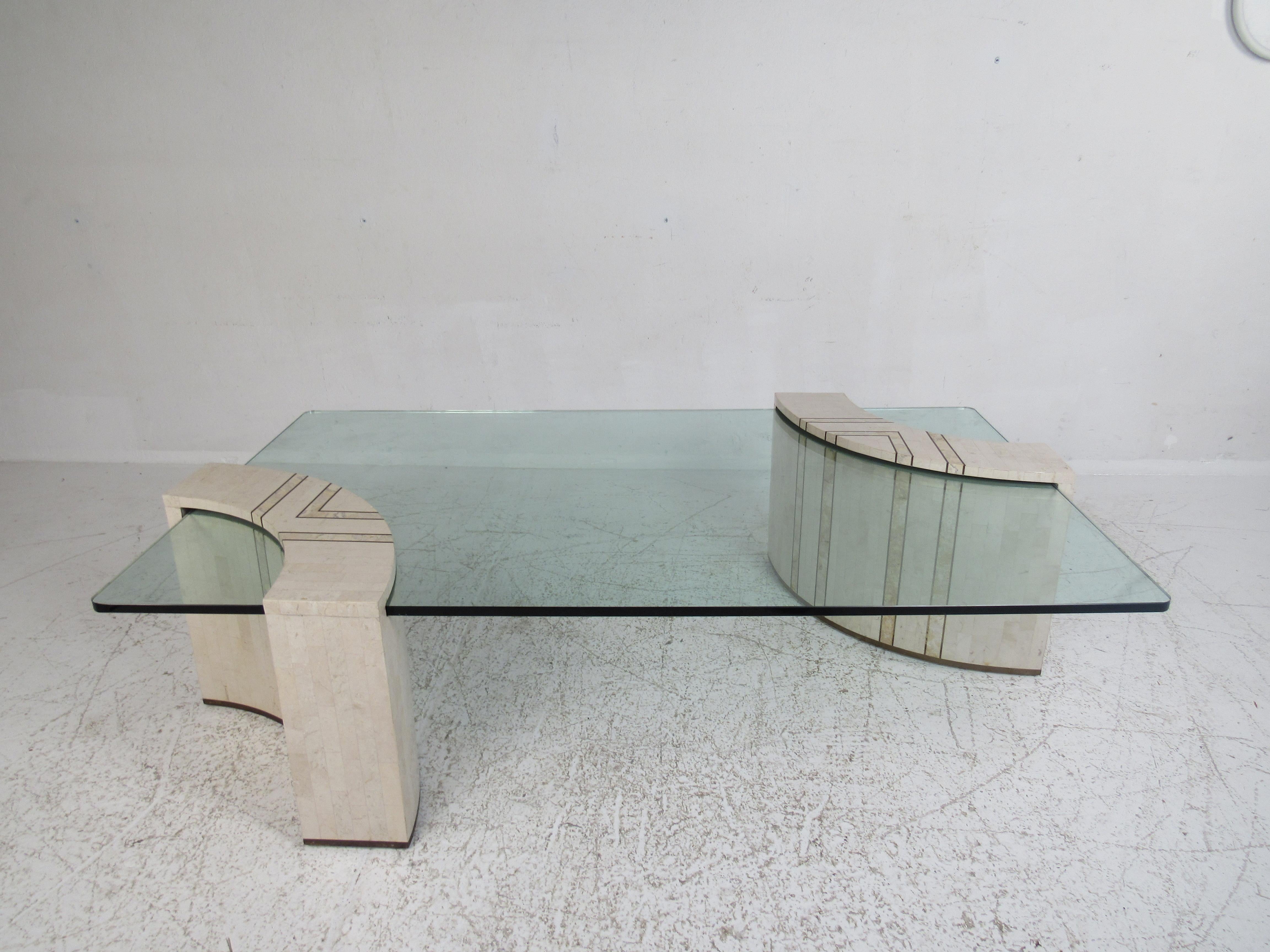 Cette étonnante table basse moderne du milieu du siècle présente une base en deux parties de style cantilever en pierre tessellée. Un design unique avec un impressionnant plateau rectangulaire en verre qui offre beaucoup d'espace pour poser des