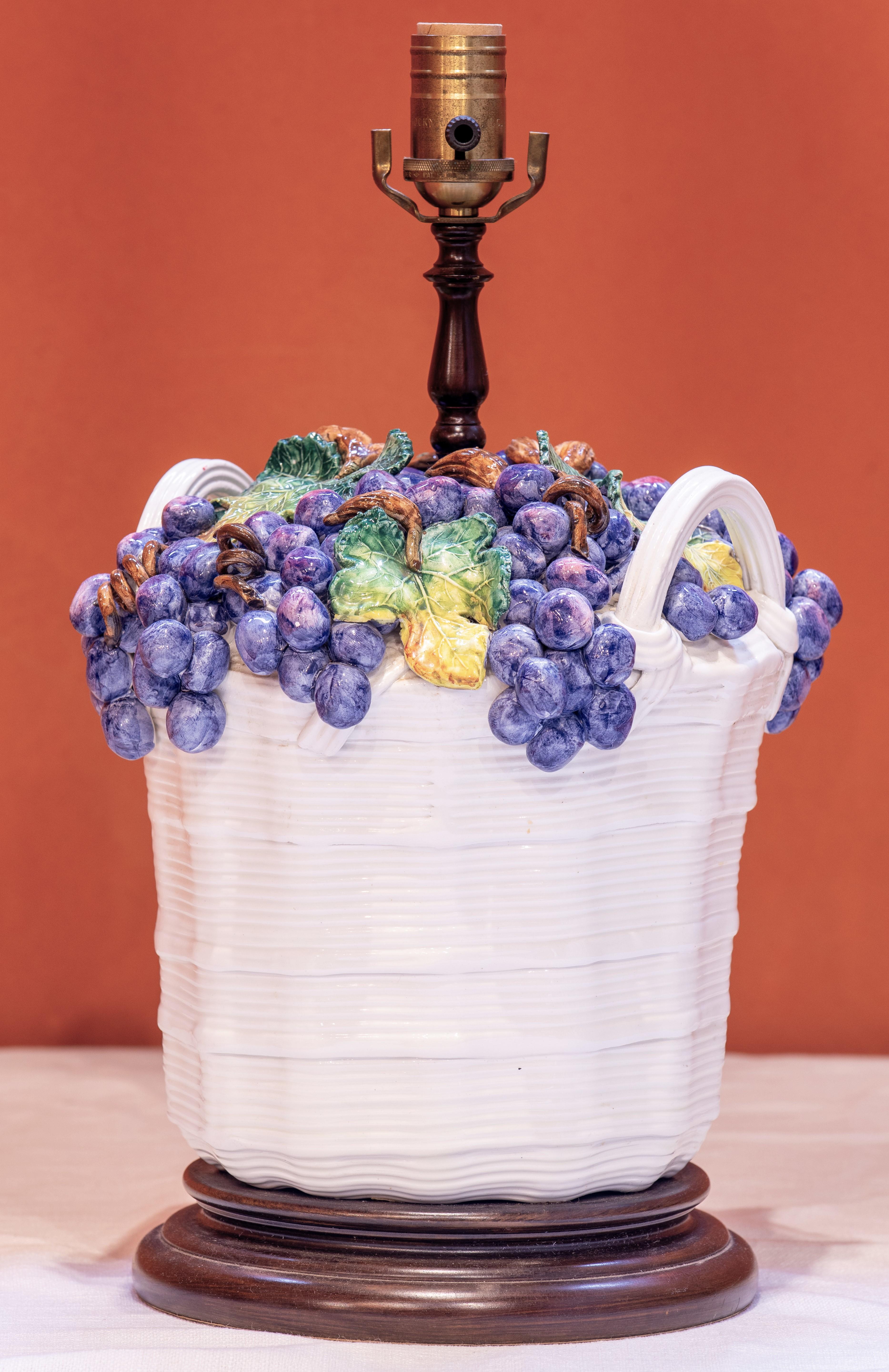 Lampada da tavolo in maiolica italiana d'epoca con motivo dell'uva. Il cesto d'uva in ceramica è stato realizzato e dipinto a mano a Bisano, in una zona d'Italia molto conosciuta per la produzione di maioliche. La lampada è stata assemblata negli
