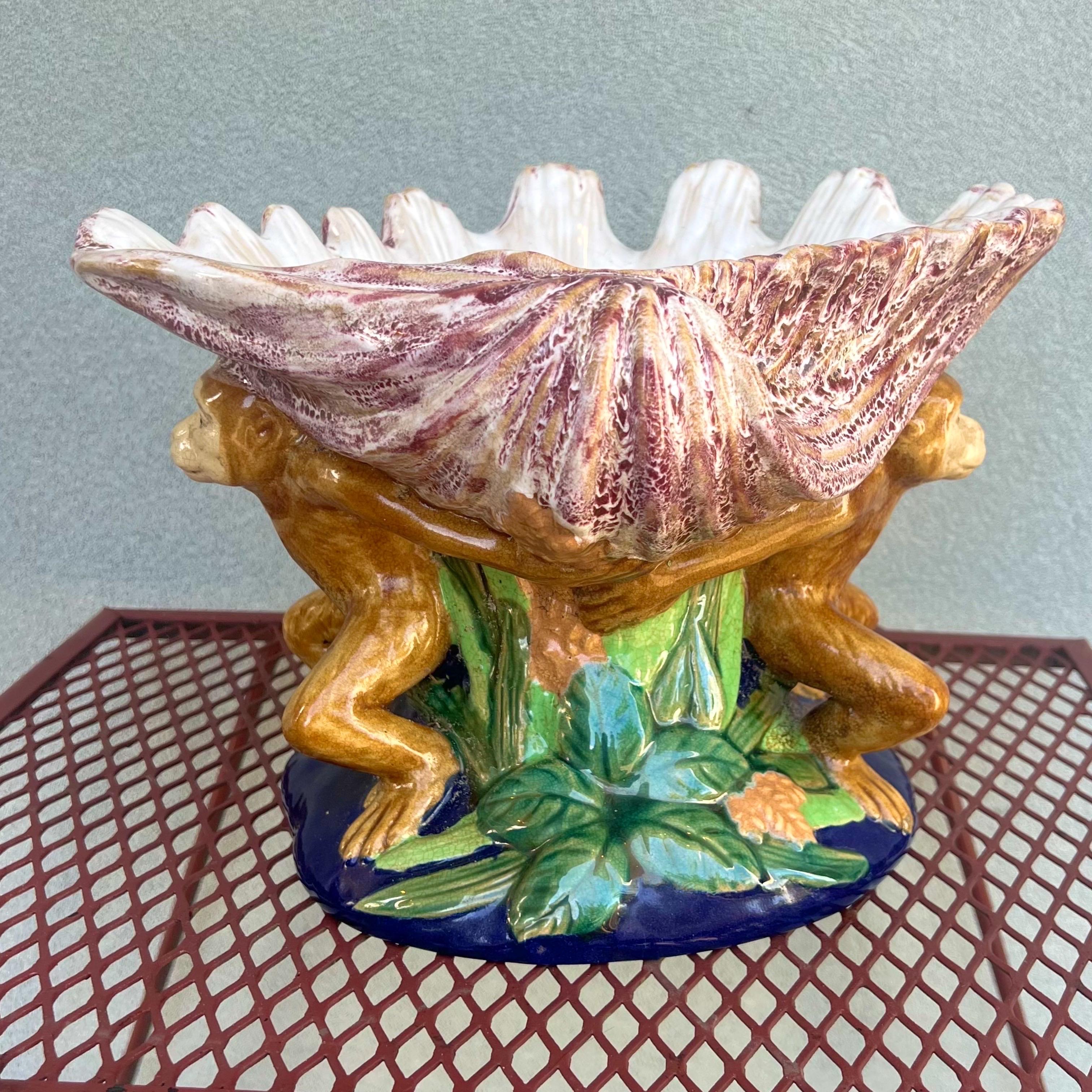 Vintage majolica style pedestal bowl with 2 cute monkeys holding up a large shell. A Very colorful piece with deep blues and a range of greens and reds.