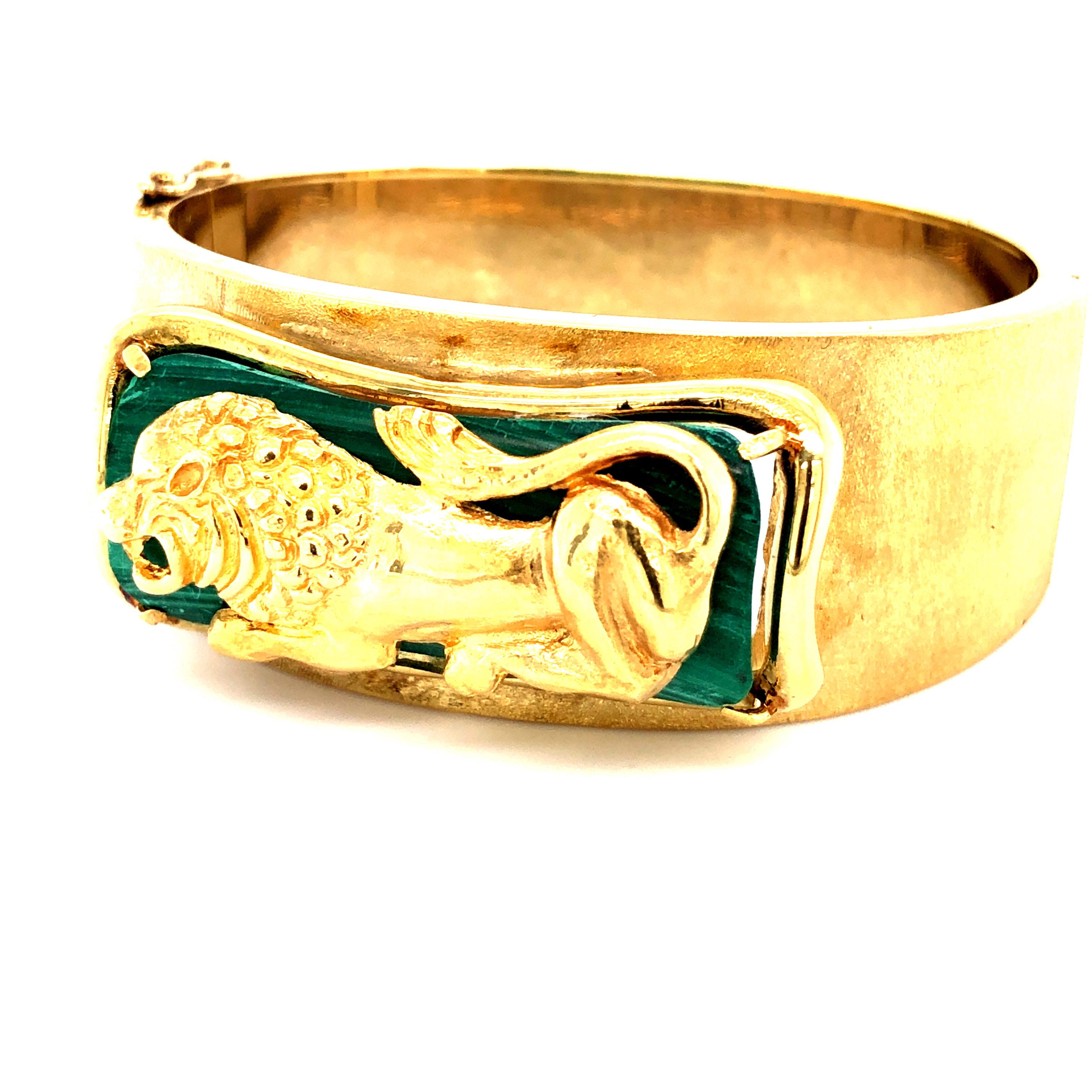 Offered here is a vintage wide cuff bangle bracelet, circa 1960-70.
Made in solid 14kt yellow, gold centered with a Byzantine Lion laying on a natural Malachite gemstone.
Bracelet is 1 inch wide at the top center and graduates down to 5/8 inch at