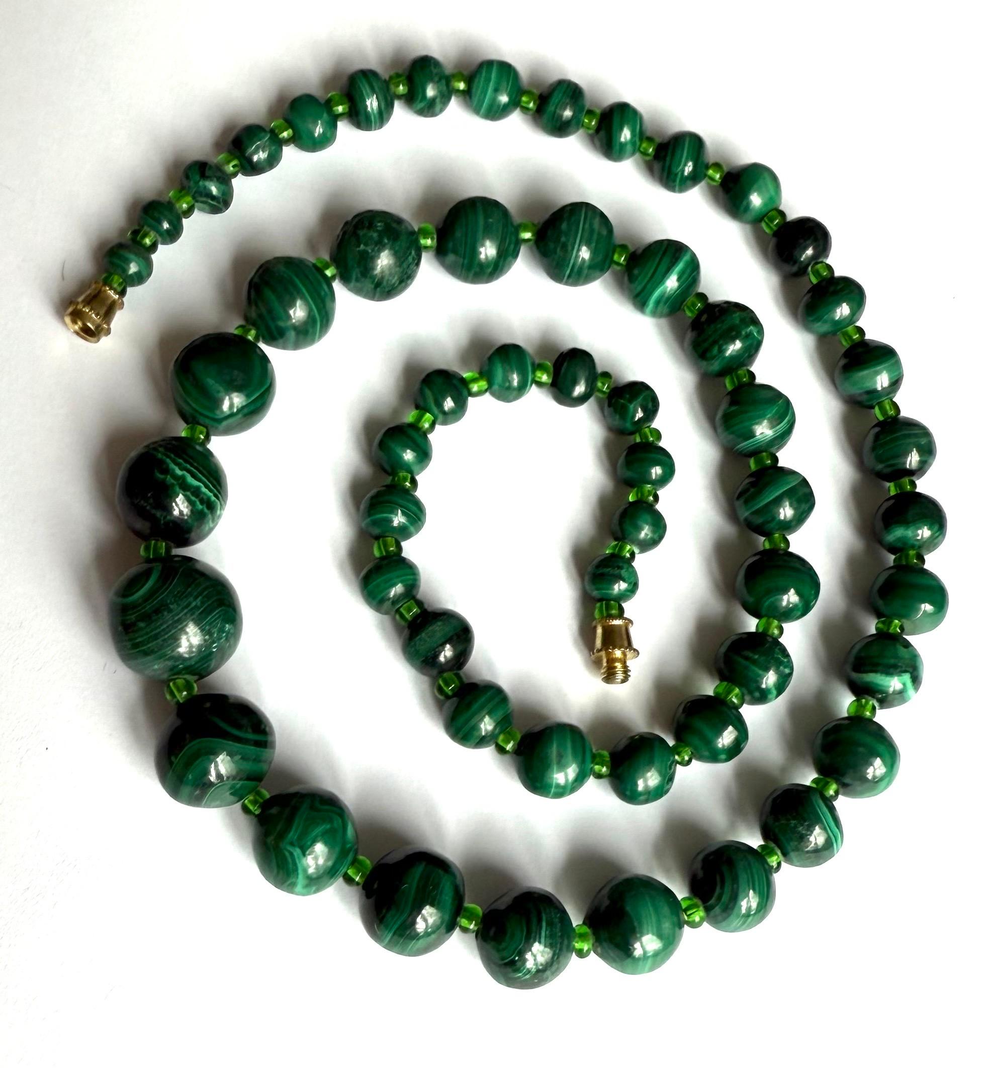 Hervorragende Malachitperlenkette im Vintage-Stil. Malachit ist ein grünes Kupferkarbonat-Hydroxid-Mineral mit ausgeprägter Bänderung, das häufig für Schmuck verwendet wird. Die Kette besteht aus unterschiedlich großen Perlen, wobei sich die größten