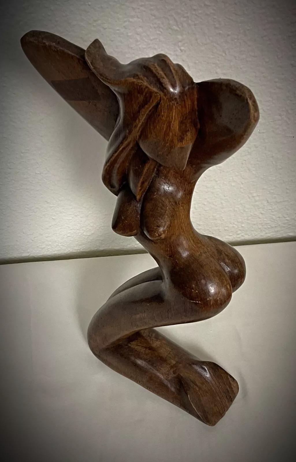 Questa scultura malgascia vintage, firmata dall'artista Bera, è una straordinaria rappresentazione astratta di una donna, realizzata a mano in legno di palissandro (palissandre). Risalente agli anni '50-'60, questo pezzo mette in mostra l'eleganza e