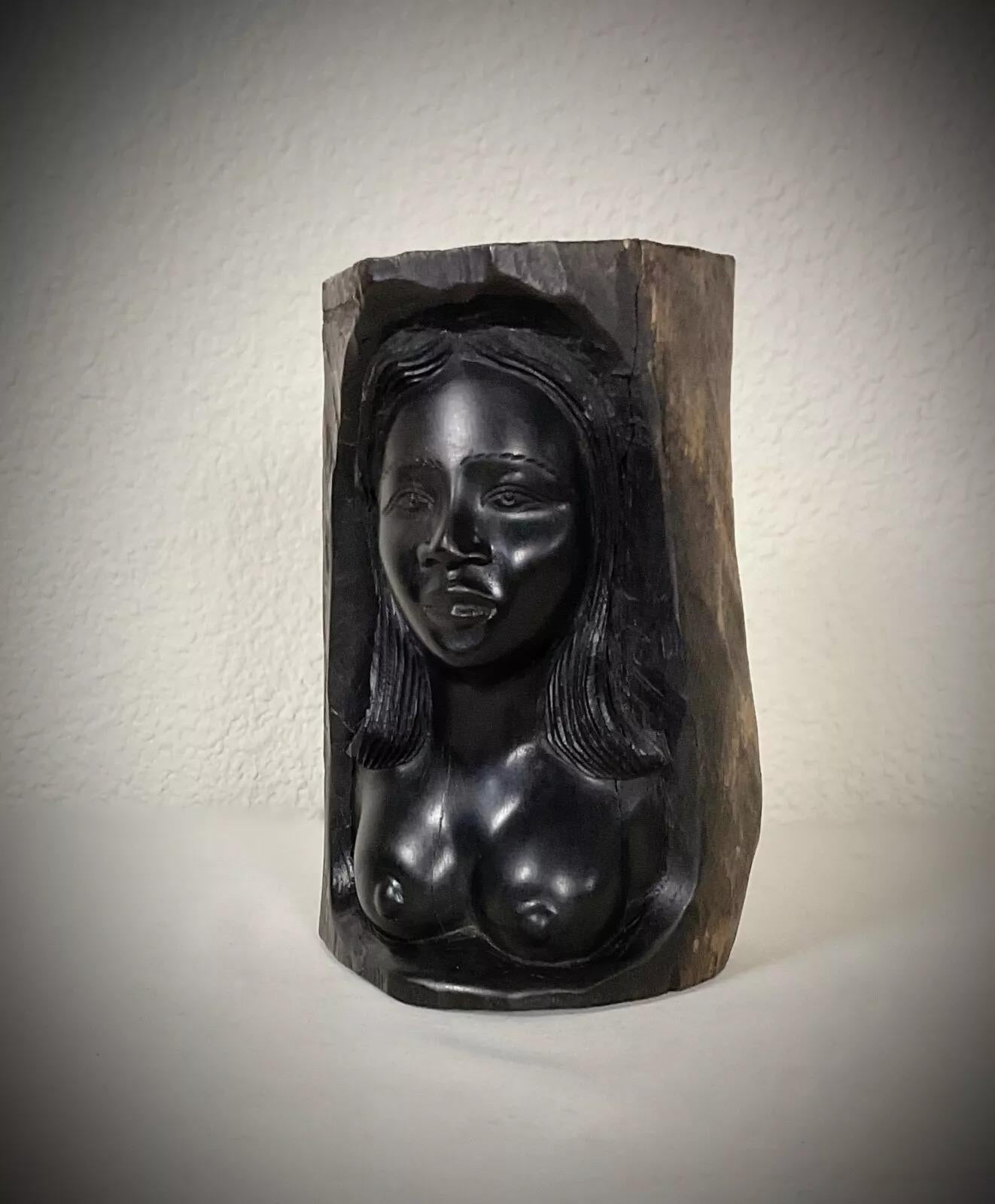 This authentic vintage Malagasy sculpture, crafted from rich ebony wood, depicts a gracefully carved nude woman in a minimalist yet captivating form. The piece, created by skilled artisans from Madagascar, dates back to the mid-20th century,