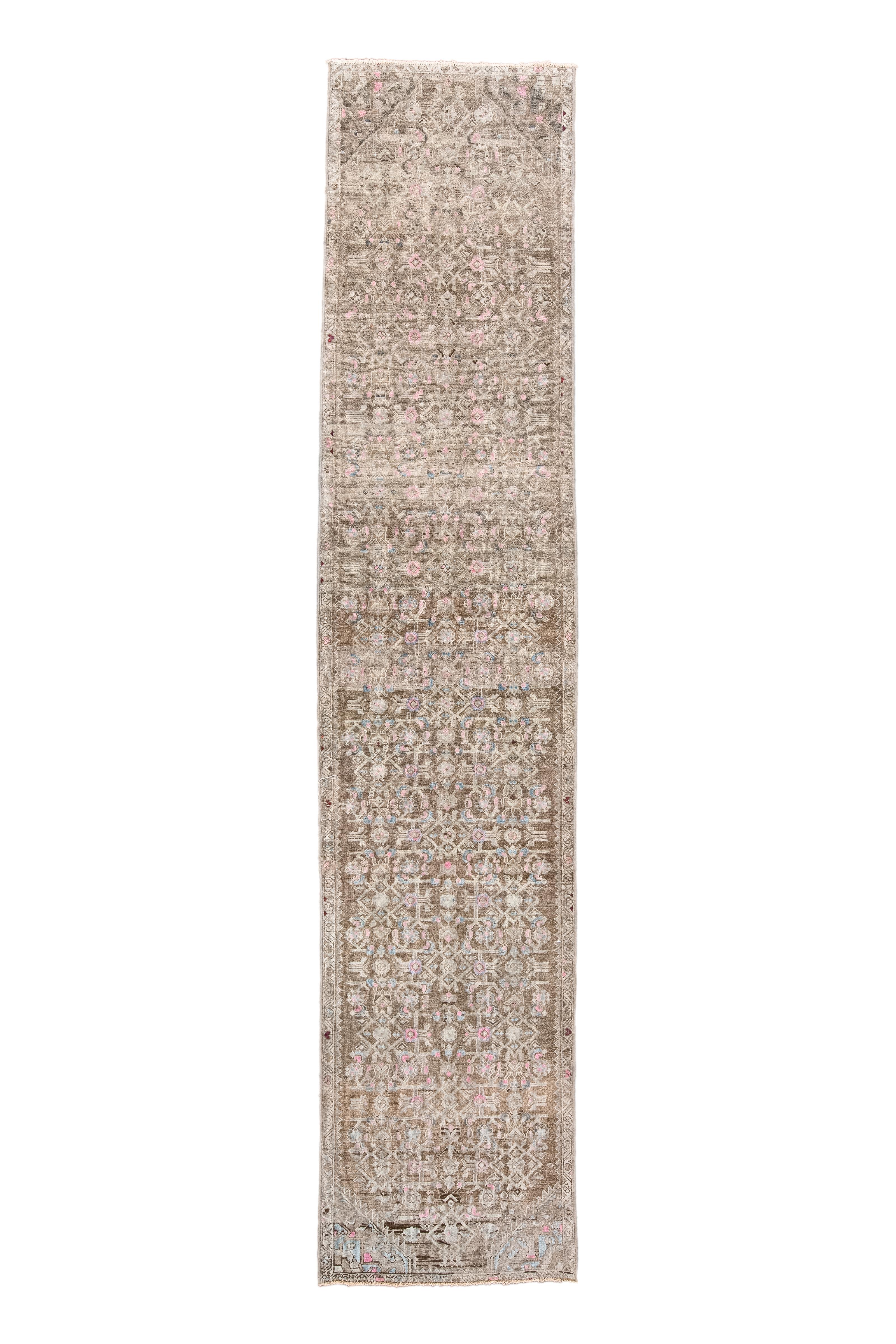 The red- brown field is slightly beveled at the ends and shows an offset three column allover Herati design accented in bone. Arrow ecru border with reversing flowers on a trapezoidal meander. Reduced all around. 

Rug Size
2'5 x 11'3 