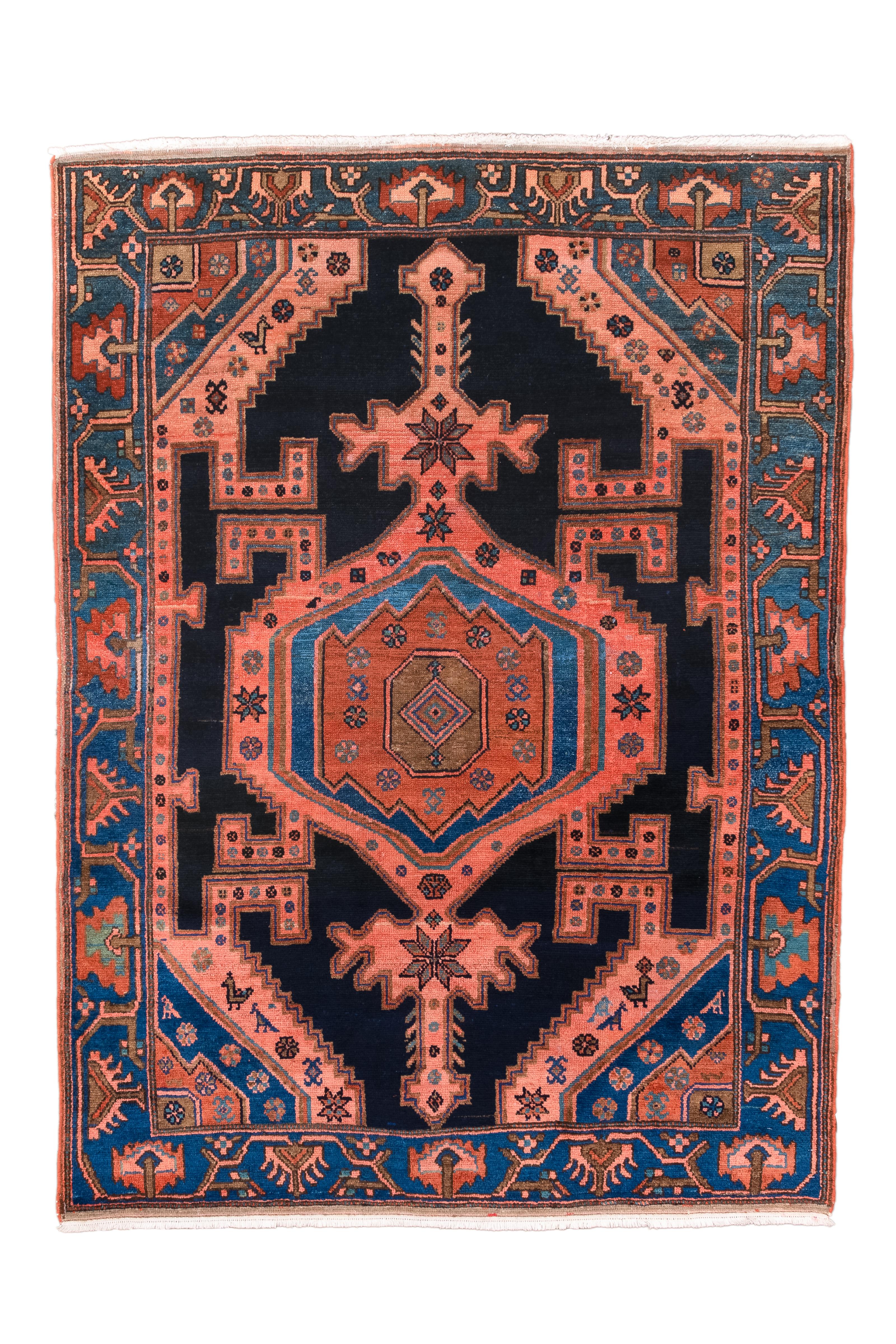 Dieser 1940 in Hamadan, Iran, gefertigte rechteckige Teppich besticht durch sein faszinierendes Design in den Farben Rosenblüten und Dämmerungsblau. Die komplizierten Medaillonmuster spiegeln das reiche kulturelle Erbe und die Webtradition der Stadt
