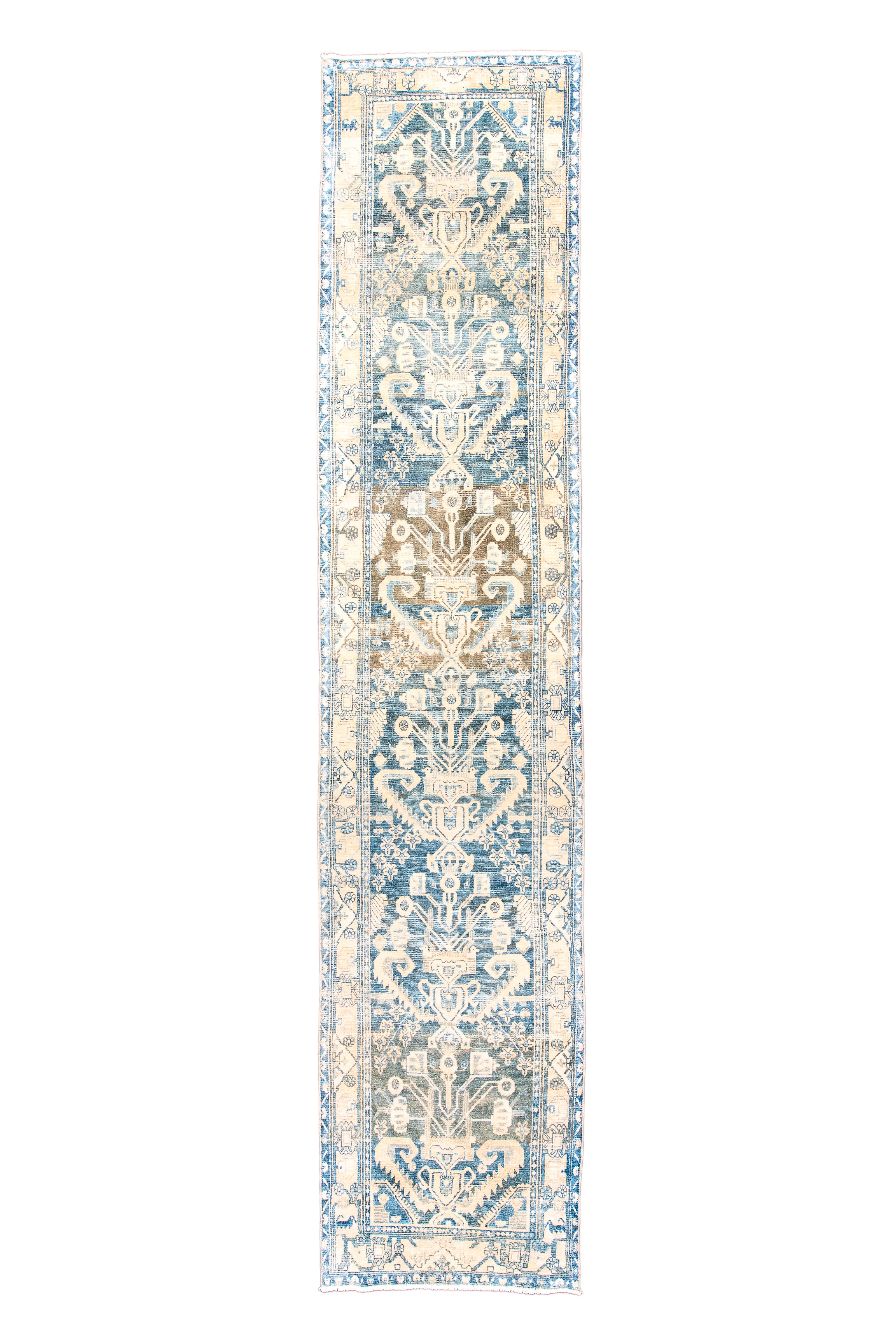 The field strong abrashes in the general slate hue, and shows six vases with exuberant floral developments, within serrated and partially curled leaves in pairs. Straw narrow main border with geometric tendril, rosettes and triangular fillers.

Rug