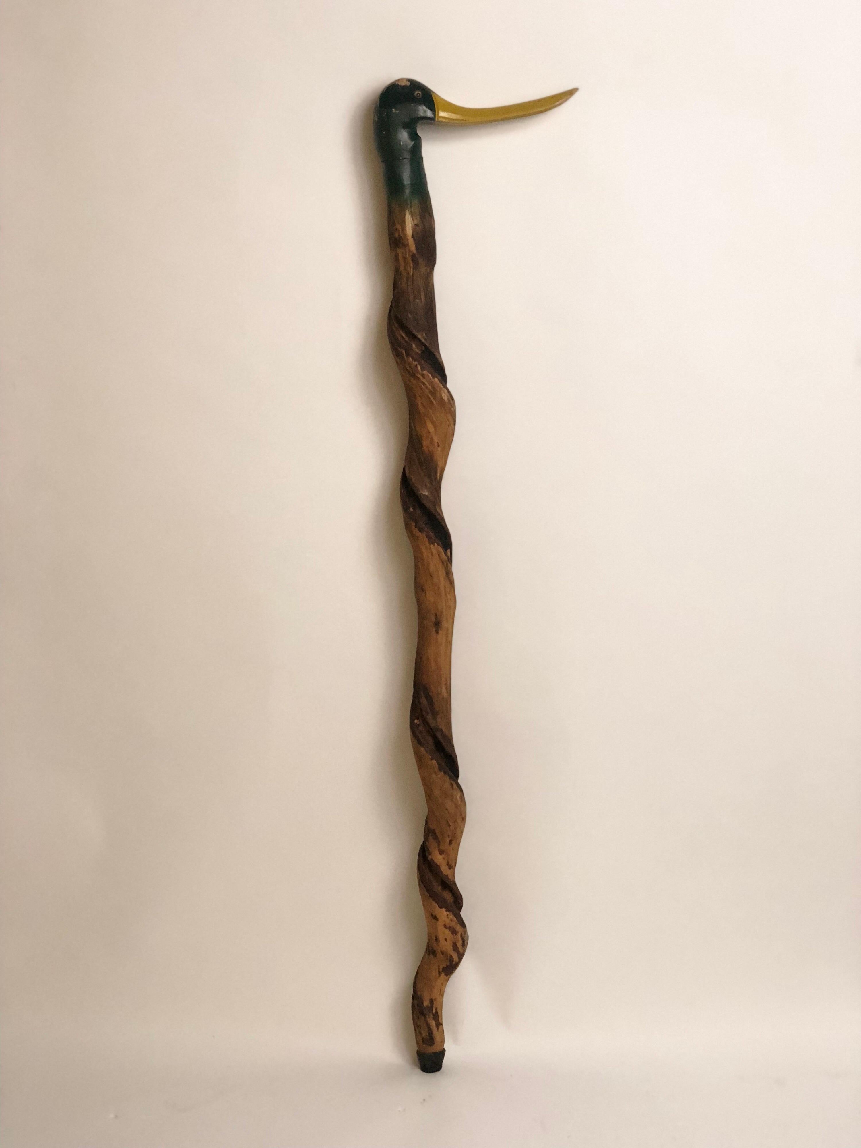 20th century American vintage walking cane perhaps carved from a tree root with a finely detailed and painted mallard head at the knob and a natural wooden shaft.