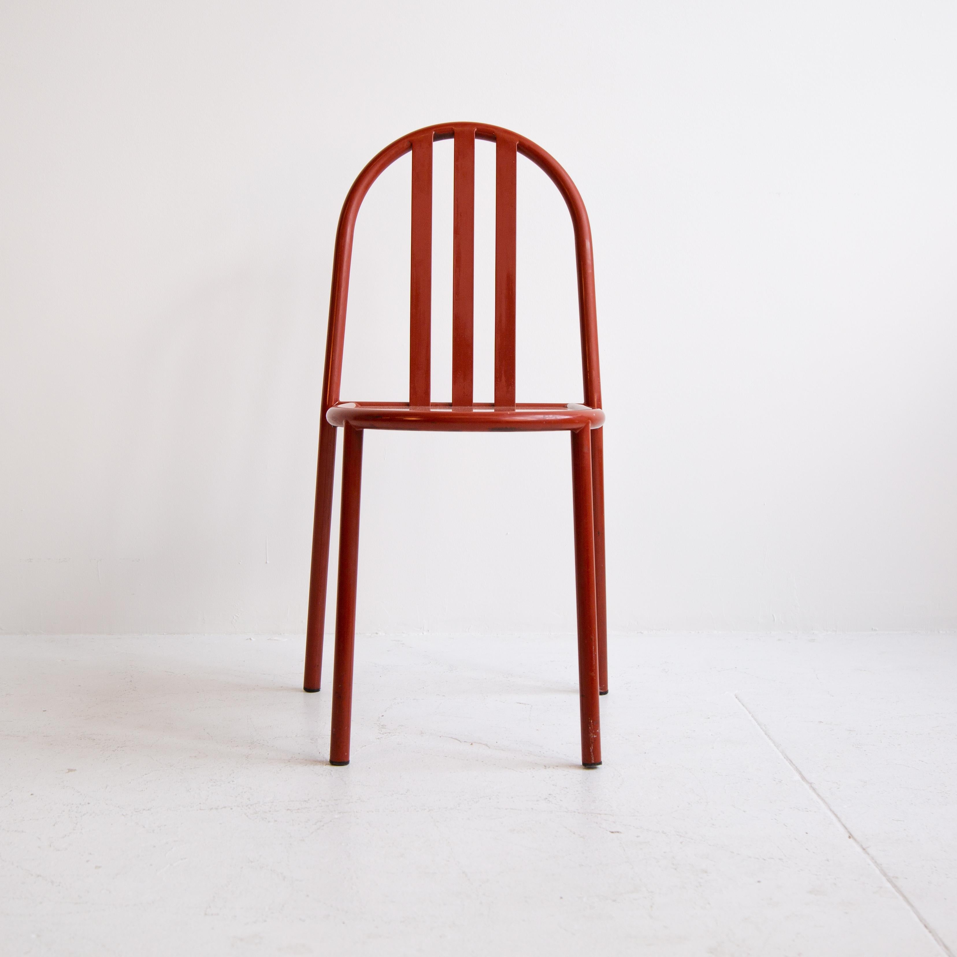 A vintage Mallet-Stevens 'Model 222' dining chair featuring a bent tubular steel frame and vibrant red powder coat finish. The back supports and seat surface are cut from steel sheet. This Minimalist chair, originally manufactured in France, is the