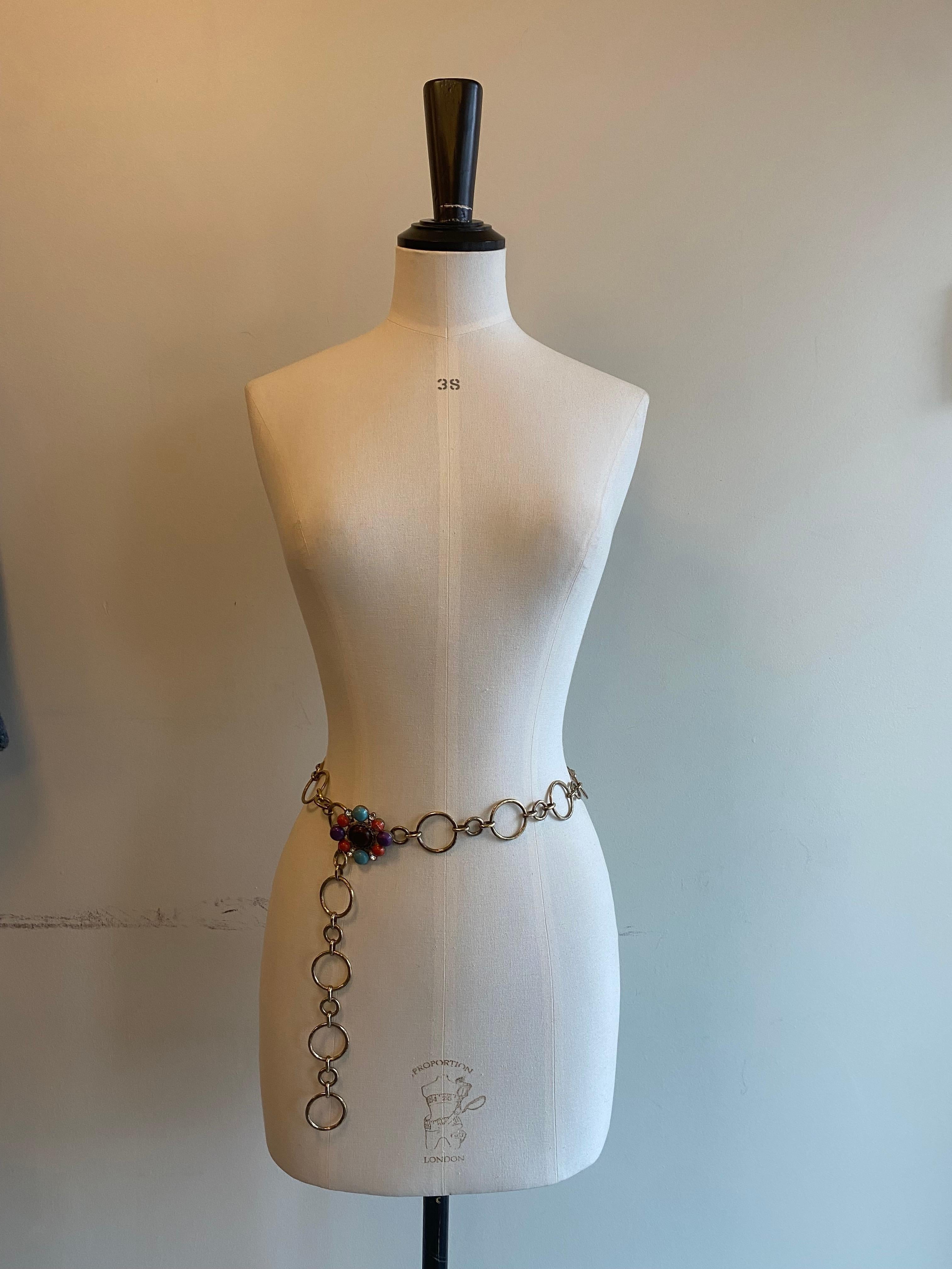 Vintage Maltese Cross chain link belt from Chanel. Gold toned metal chain link belt embellished with a maltese cross buckle. Cross is made up of sparkling diamanté petals and orange, purple and turquoise cobochons, with one branded with signature