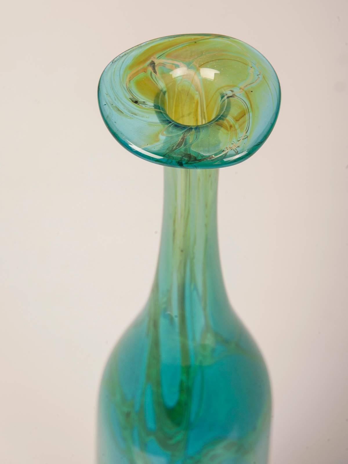 A tall handblown vintage Maltese Mdina glass bottle with a slender neck and flared lip in a striking shade of turquoise from Malta, circa 1975. Capturing the iridescent colors of the Mediterranean Sea Mdina glass was created in a workshop on the