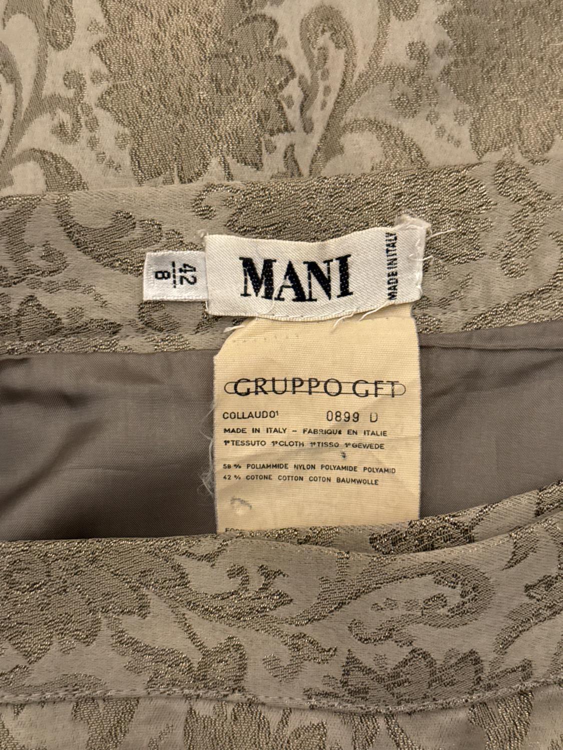 Une superbe jupe de soirée vintage de Mani. La jupe est d'une jolie couleur argentée/verte et en coton mélangé. Le tissu a une belle texture et la jupe est entièrement doublée.  La jupe est enveloppante, avec des cerceaux de ceinture et des boutons,