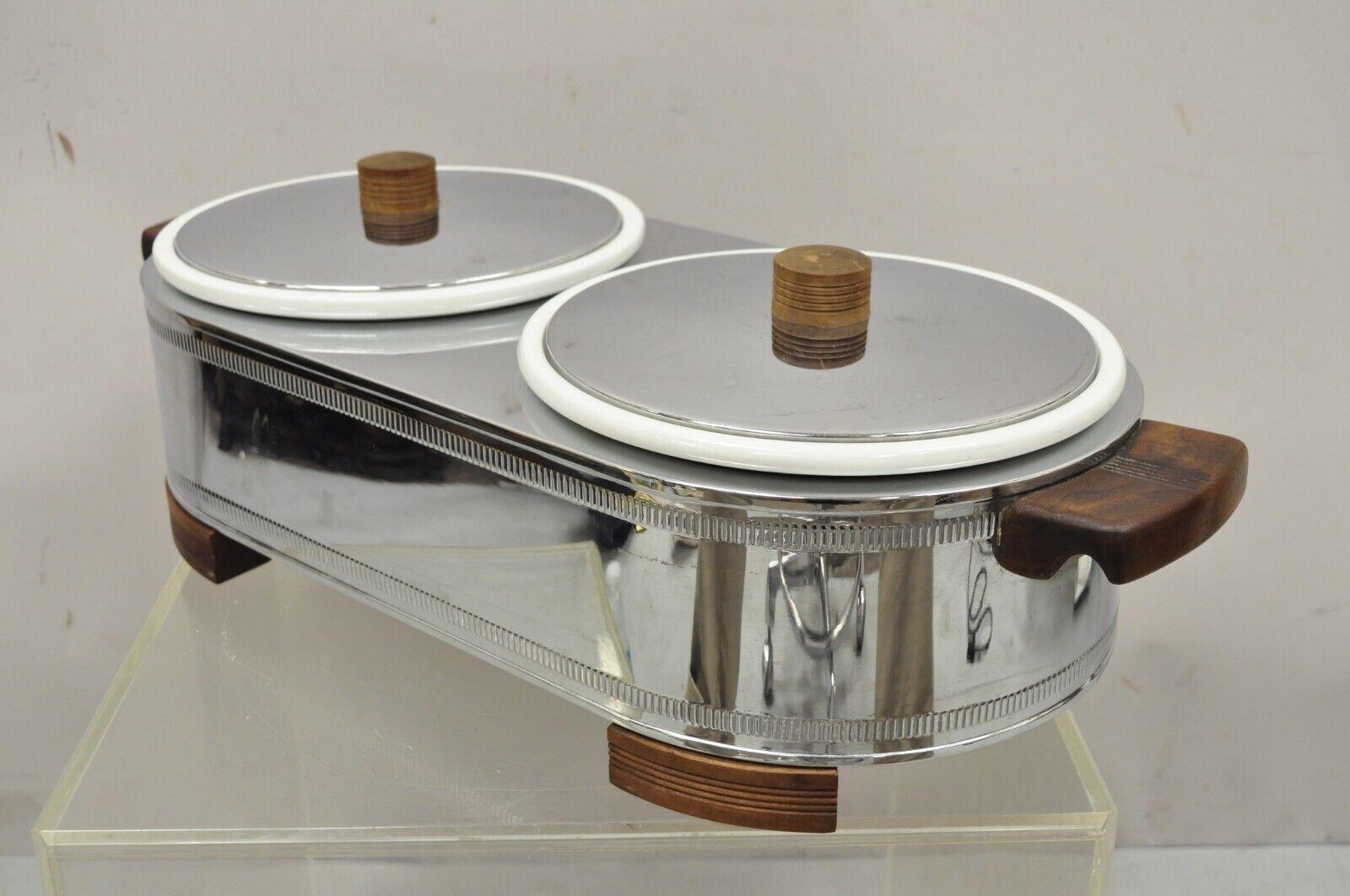 Vintage Manning - Bowman Art Deco stainless steel double warmer 2 ceramic dishes. Item features 2 removable ceramic dishes, stainless steel lids, wooden handles and feet, original stamp, very nice vintage item, tested and it does appear to work.