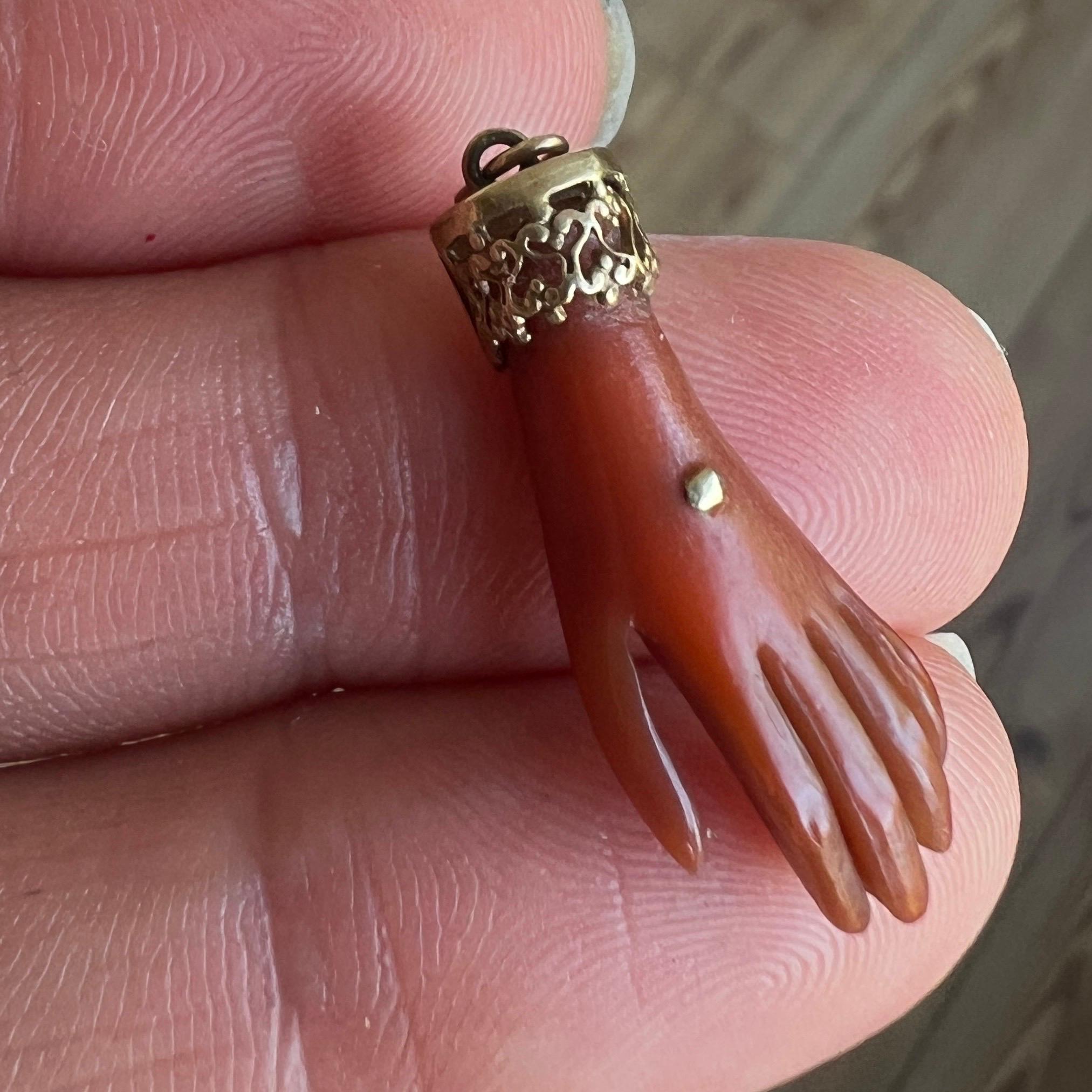 A vintage mano figa hand charm pendant set with a beautiful openwork 9 karat gold bail. The hand is made from brown reddish synthetic plastic and nicely detailed with the filigree work cap. It is a rare find, we have never come across this type of