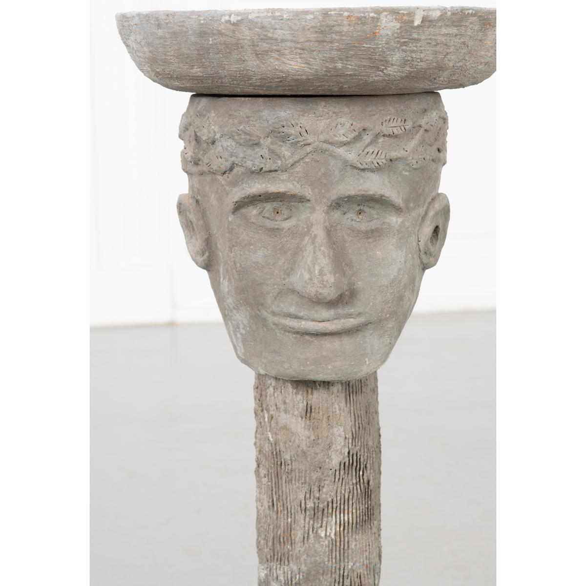 This is a vintage cast playful bird bath or feeder. It features a man’s head and neck with a birdbath sitting on top like a hat. A whimsical item that would be fun in a garden or patio area.
 