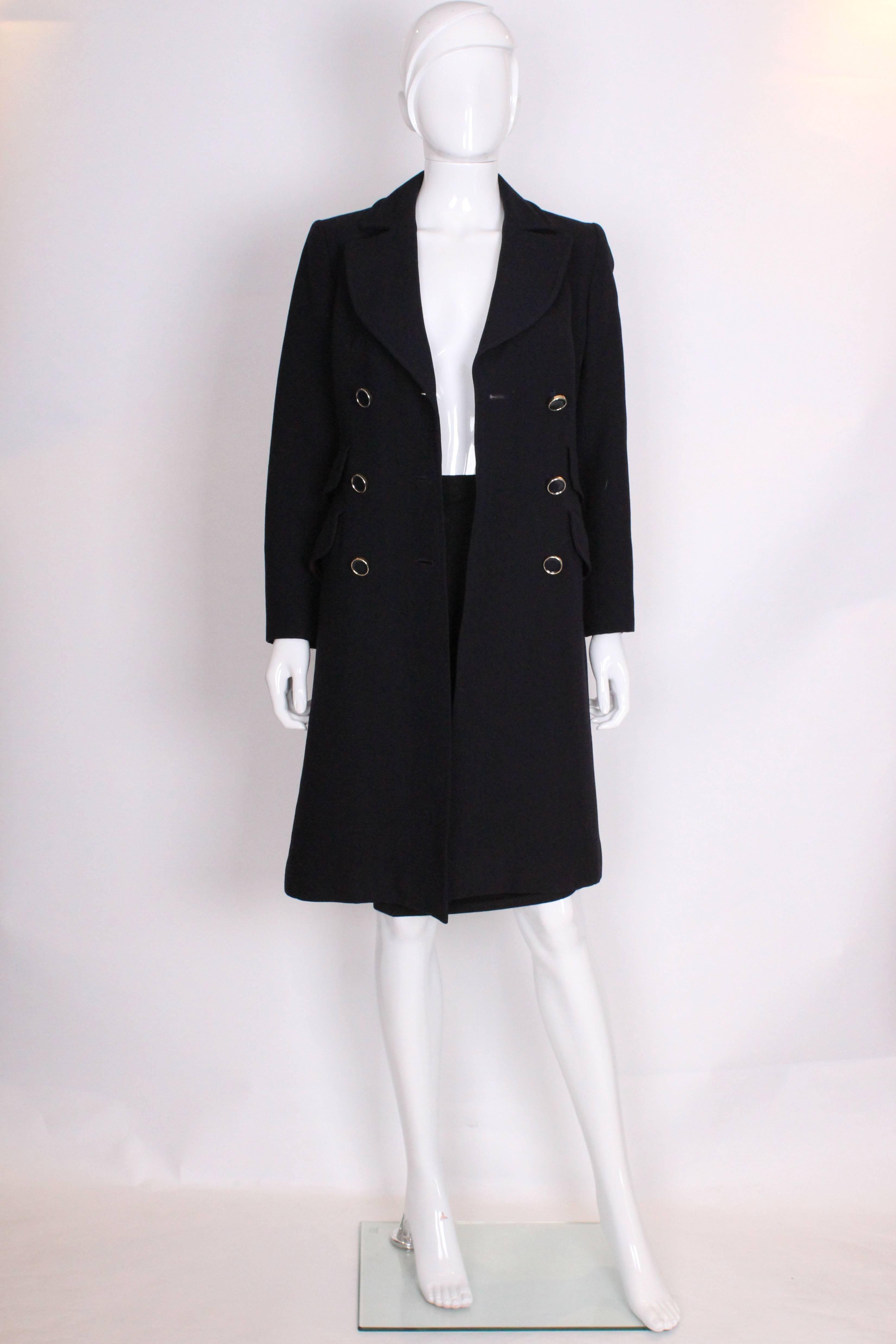 A chic coat for Fall by British brand Mansfield. In a stylish navy blue this coat is double breasted with three rows of buttons,  two real pockets and two fake pockets. It has a half belt at the back.It is a nice heavy wool and is fully lined.
