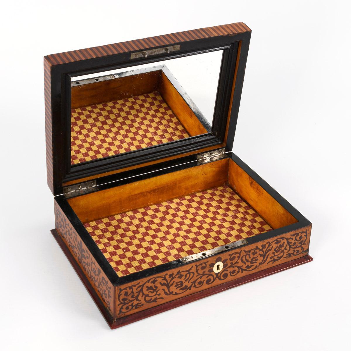 Anonymous
European; 19th century

Approximate size: 8.5 x 28 x 20 cm

The present box features intricate marquetry depicting patterned scrollwork on its top and sides and handsome striped banding around its lid. The lid is hinged and a mirror