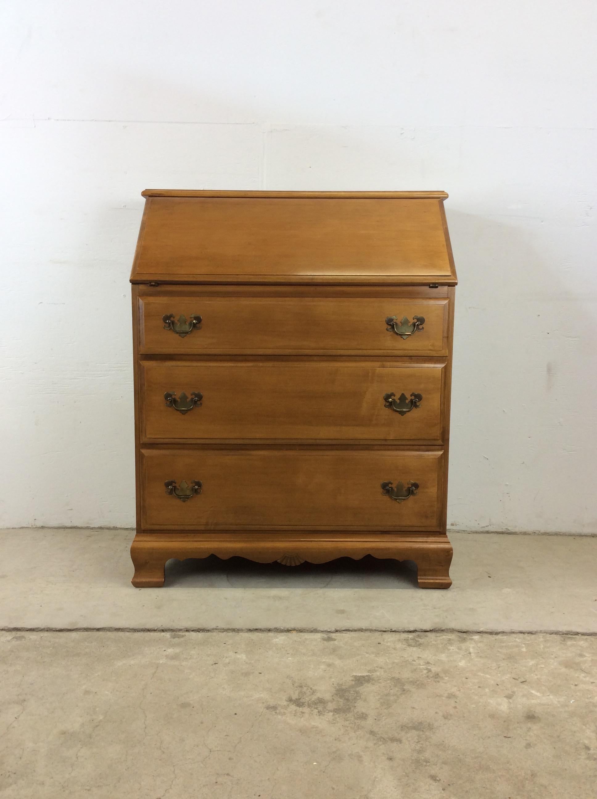 This vintage chest of drawers features solid maple construction with original finish, brass accented hardware, three dovetailed drawers and one drop front writing desk with interior storage. 

Dimensions: 31.75w 17d 39.5h

Condition: Original finish