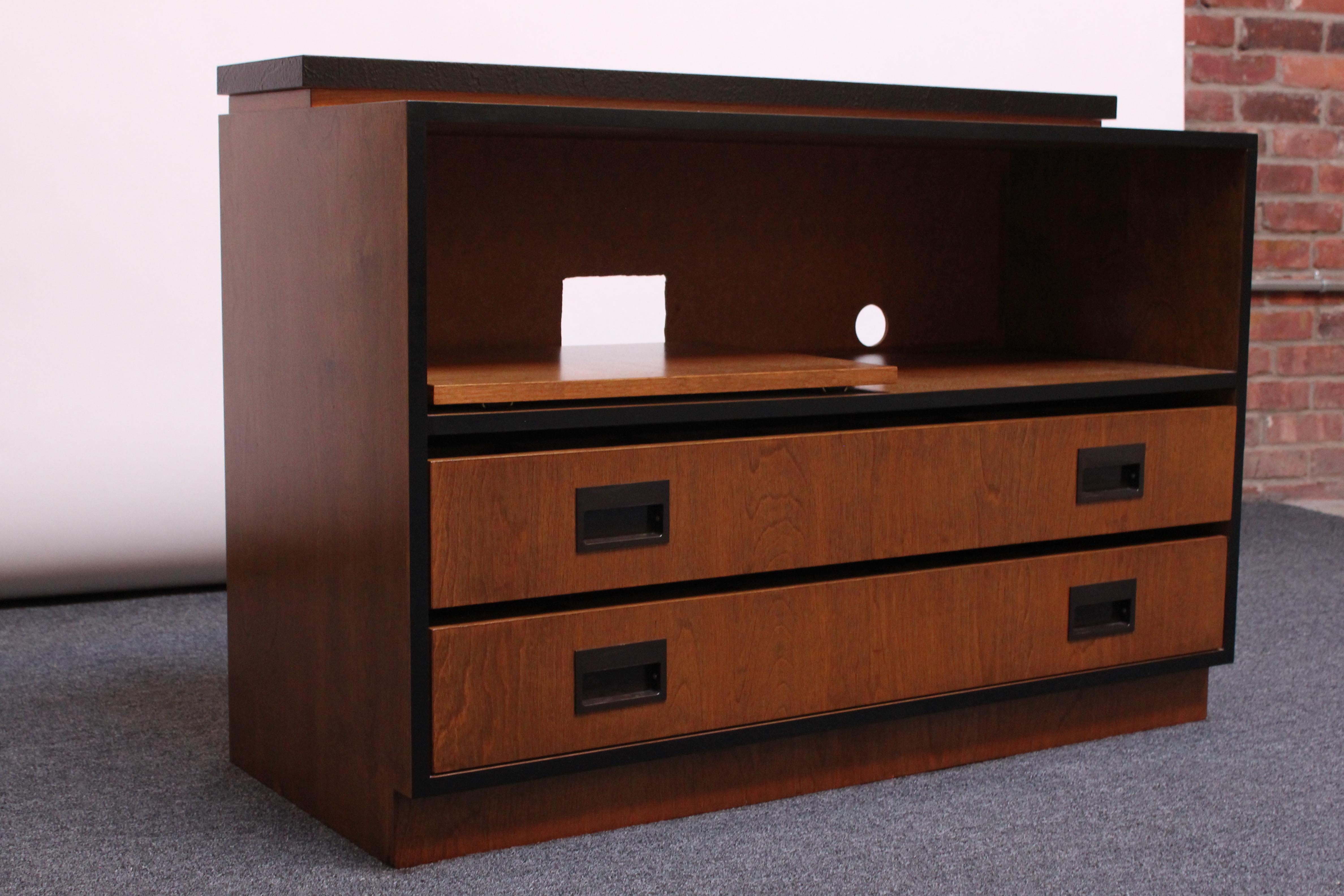 Stylish, compact and highly functional media cabinet / console in walnut with ebonized accents and laminate top tier surface. The two drawers are divided into cubbies, and all but two cubby slats are removable (with one exception, all divisions