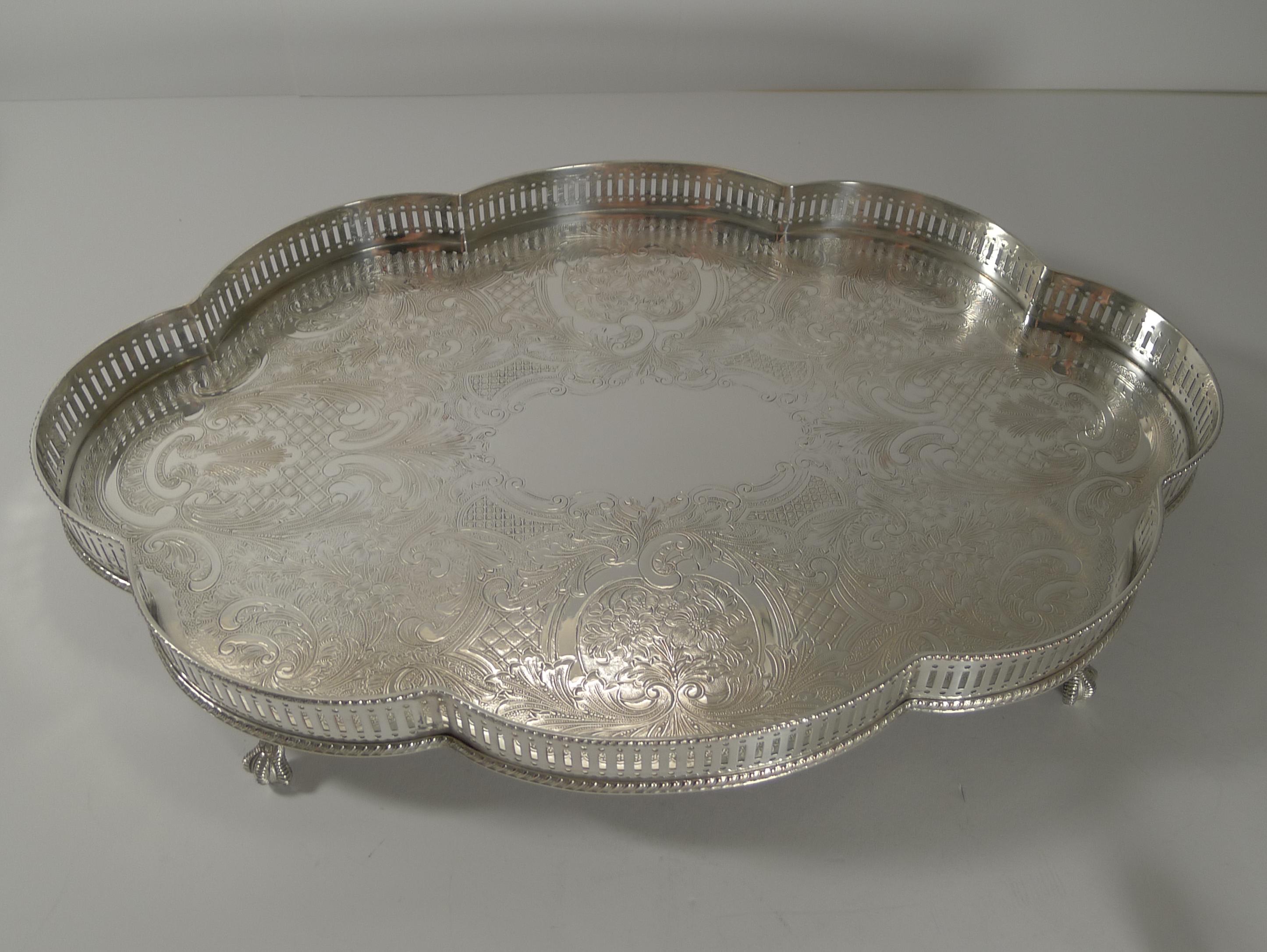 A beautifully shaped silver plated tray dating to c.1950 with all over engraved decoration surrounding a central vacant cartouche.

The galleried tray stands on four beautiful ball and claw feet.

Just back from our silversmith's workshop where