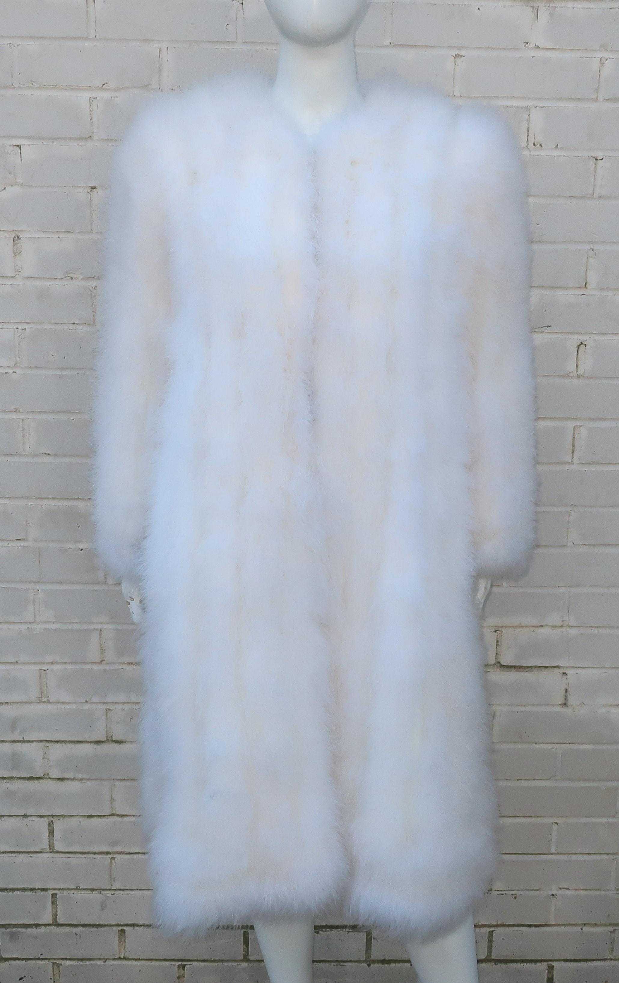 Glam alert!  A C.1980 white Marabou feather coat is just the thing to turn heads.  The collarless silhouette sports hidden hooks at the front, satin lining and side vents.  Shoulder pads create a great line and give the look an early Hollywood