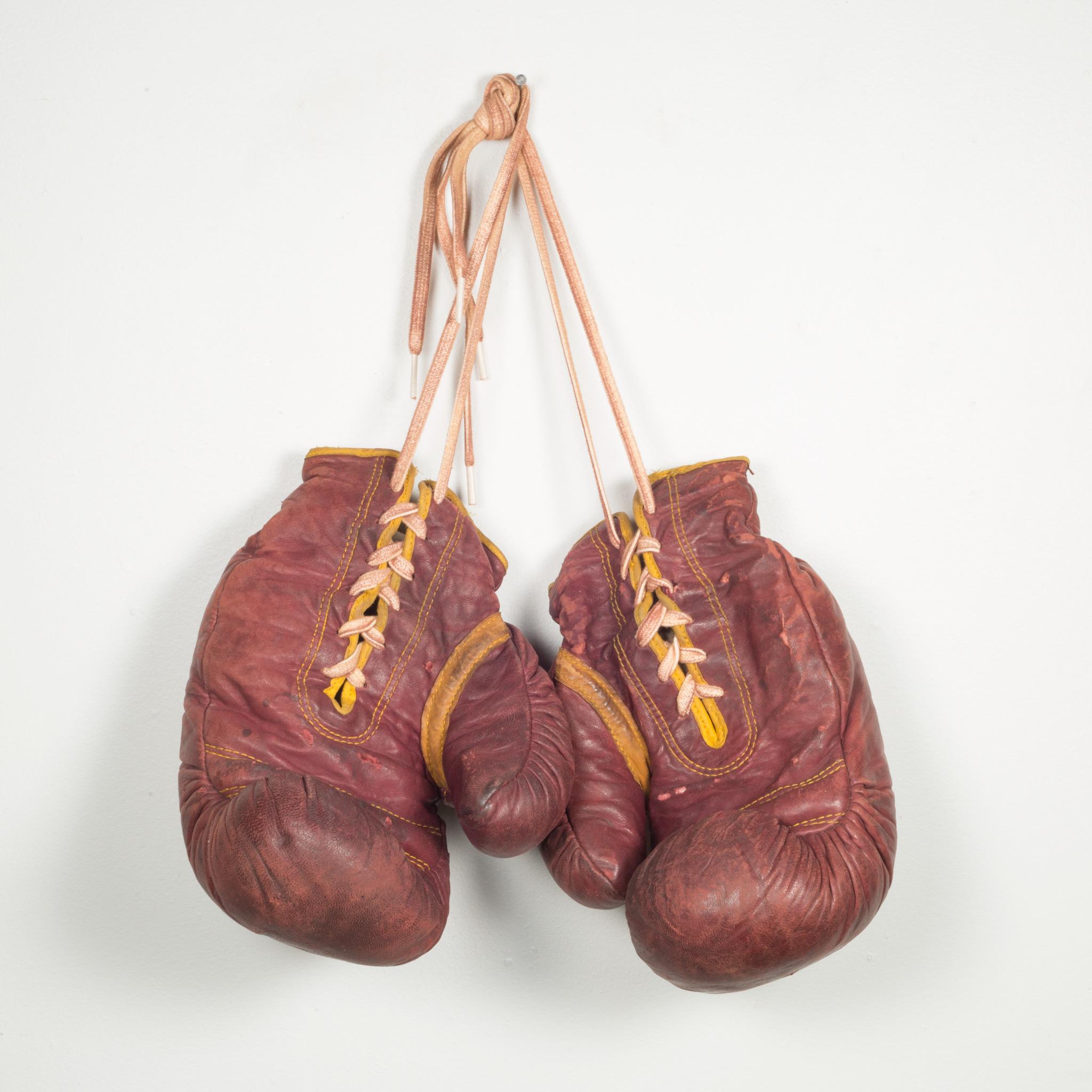 ABOUT

A pair of authentic vintage boxing gloves with reddish, brown leather. Each glove has gold leather piping. The leather is very soft and is good condition. Stamped 