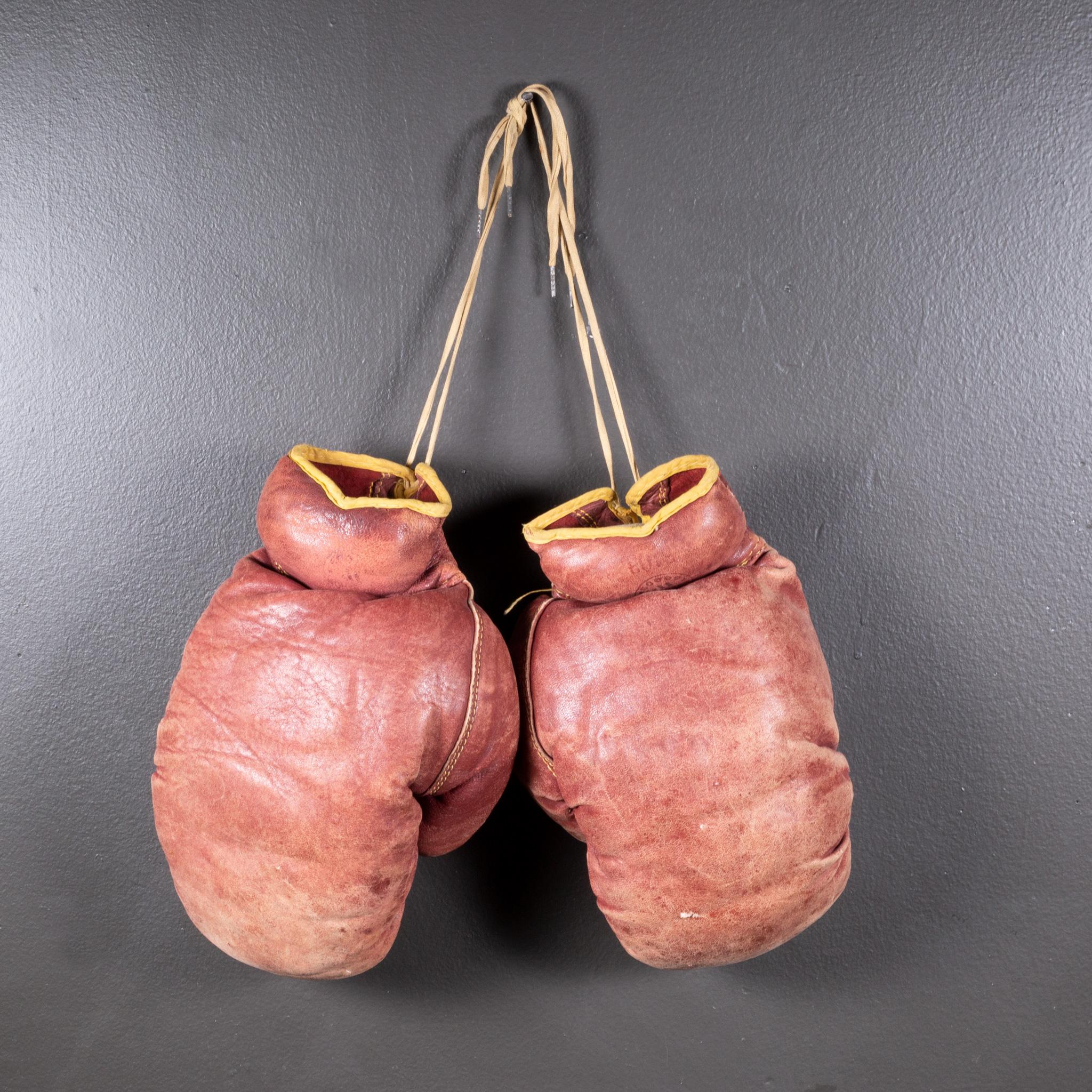 ABOUT

A pair of authentic vintage boxing gloves with reddish, brown leather. Each glove has gold leather piping. The leather is very soft and is good condition. Stamped 