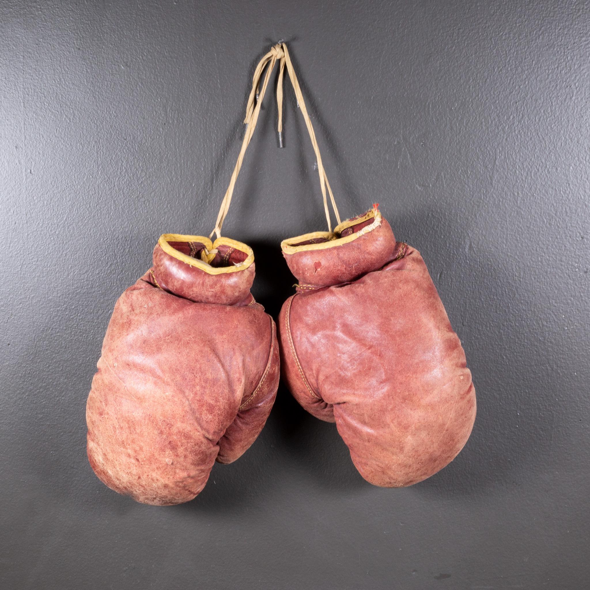 ABOUT

A pair of authentic vintage boxing gloves with reddish, brown leather. Each glove has gold leather piping. The leather is very soft and is good condition. Stamped 