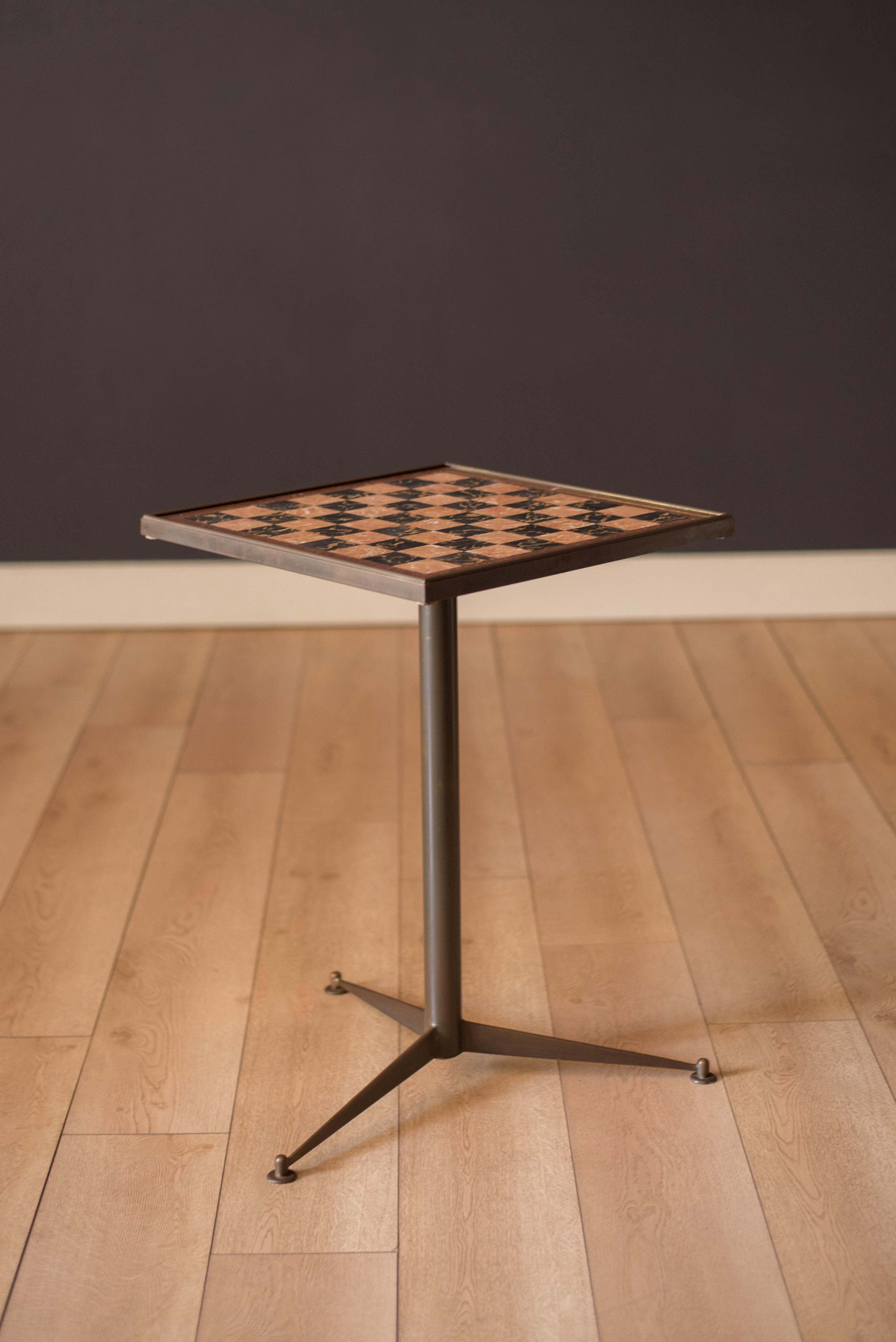 Mid-Century Modern chess game and table circa 1970's. Features a marble checker board top supported by a tripod base constructed of brass. Perfect to use as a cocktail end table or game room piece. Chess pieces are not included.