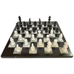 Vieil échiquier en marbre avec pièces d'échecs en onyx noir et blanc sculptées à la main