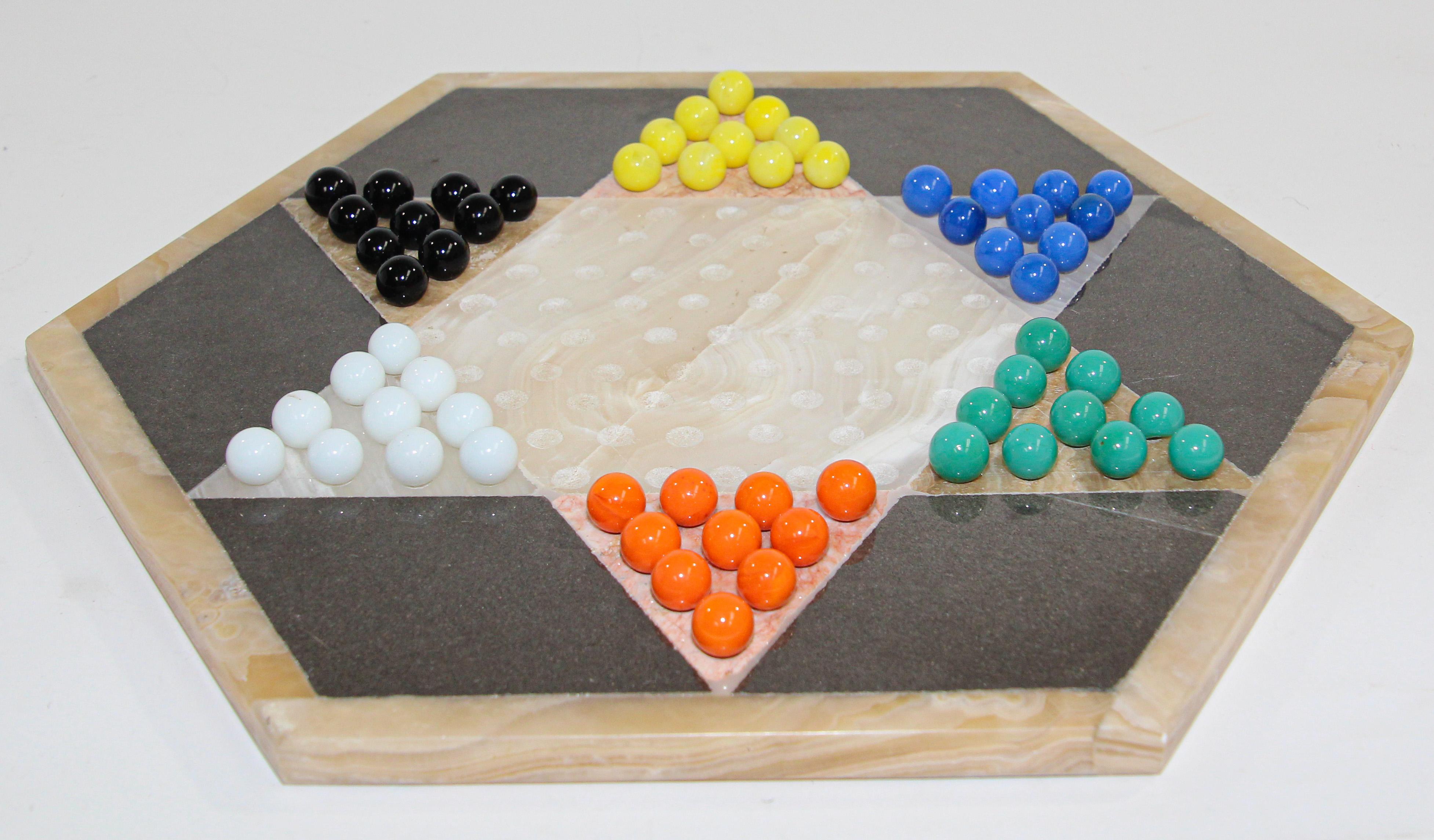 Vintage marble Chinese checkers game set with board of octagonal form set complete with thirty-one pieces.
Hand Crafted rose marble and sleek black onyx marble Chinese checkers game set.
Hand made with three varied tones of natural stone unite in
