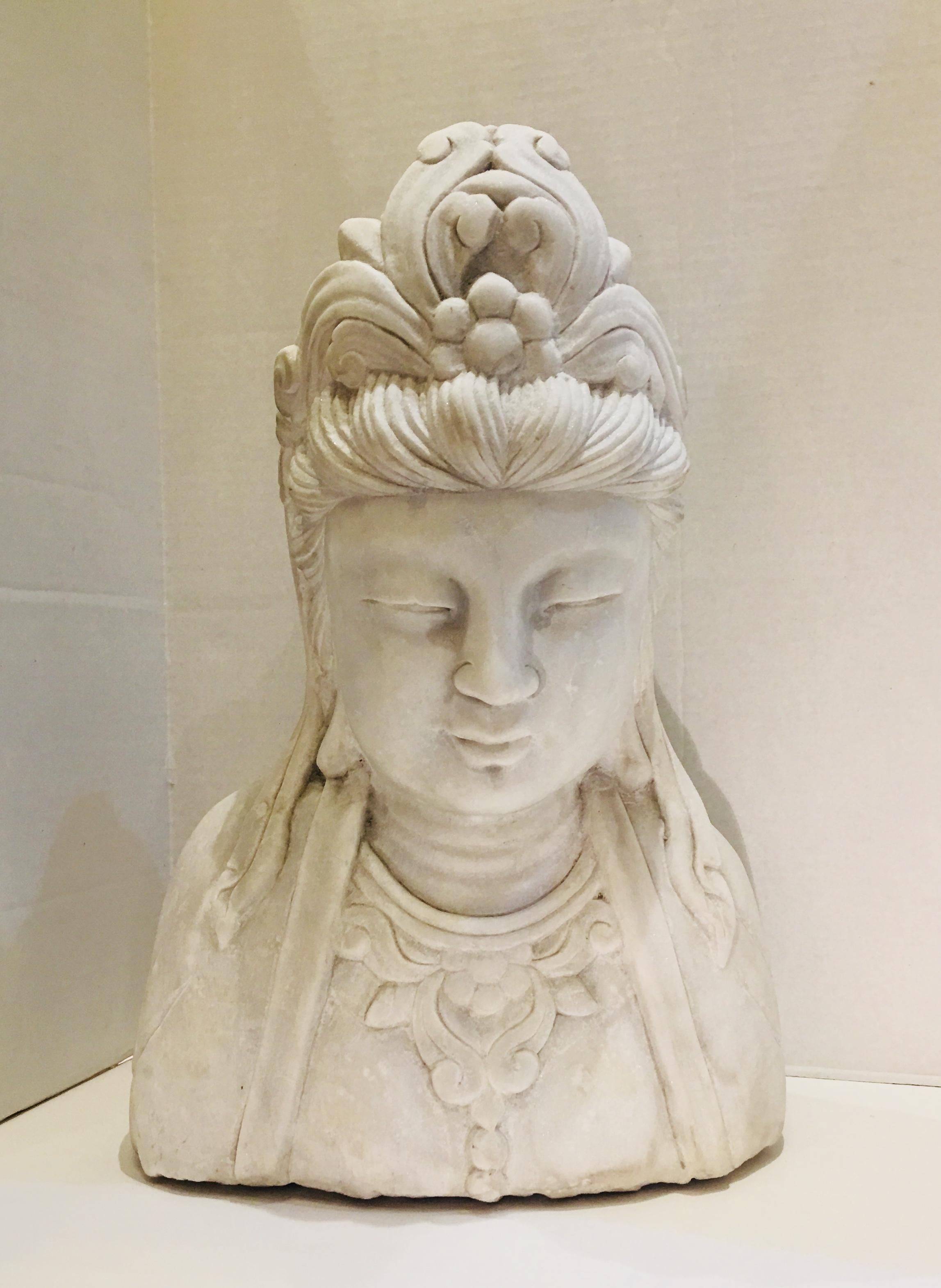 The beloved Buddhist divinity goddess Guanyin (Kuan Yin, Guan Yin) is beautifully depicted in this hand carved, life-sized, Carrara marble bust. Carved from a solid block of stone, this bust is the epitome of zen tranquility, perfect for a modern or