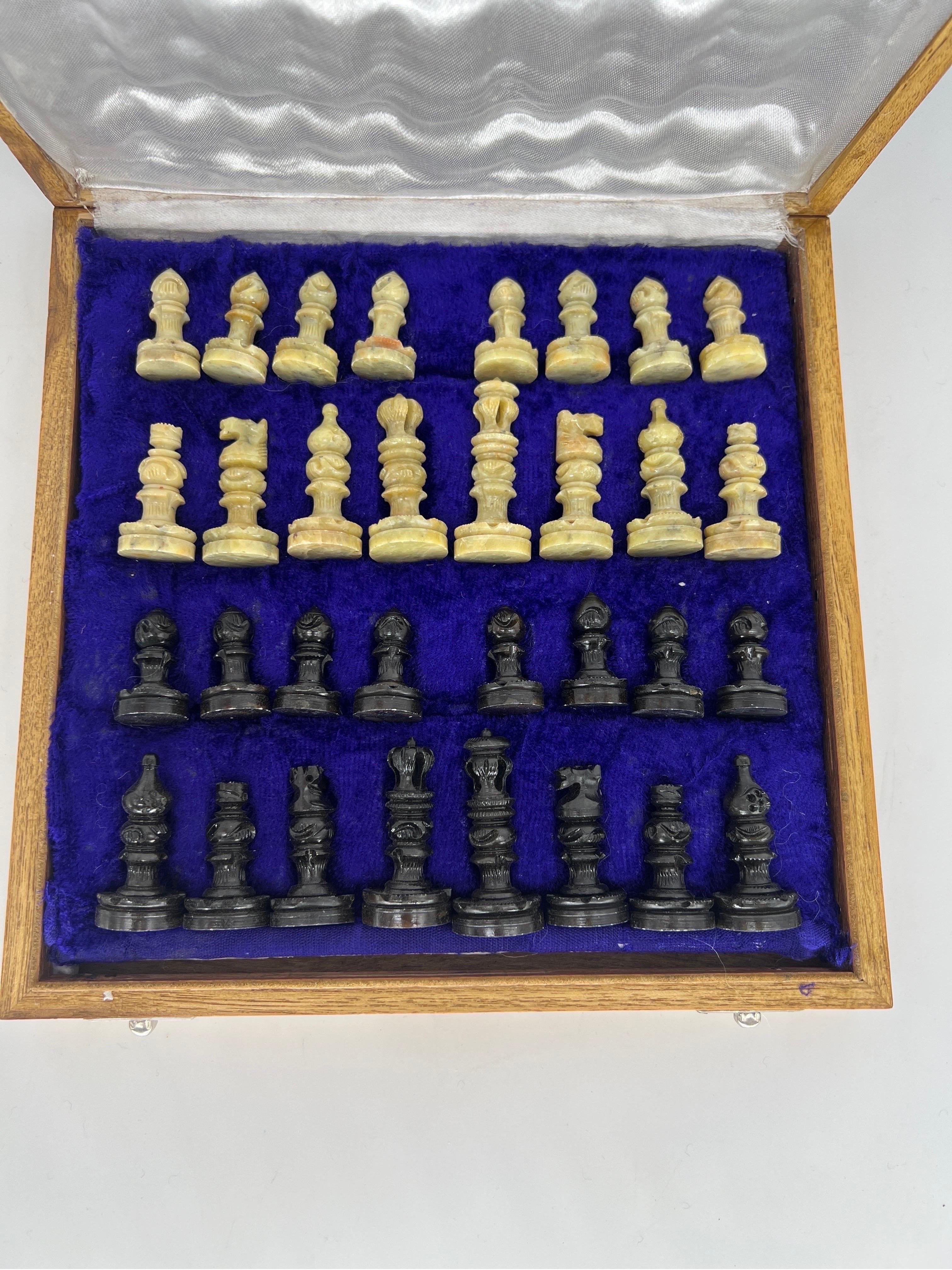 A vintage cased set of onyx chess pieces with marble board.
