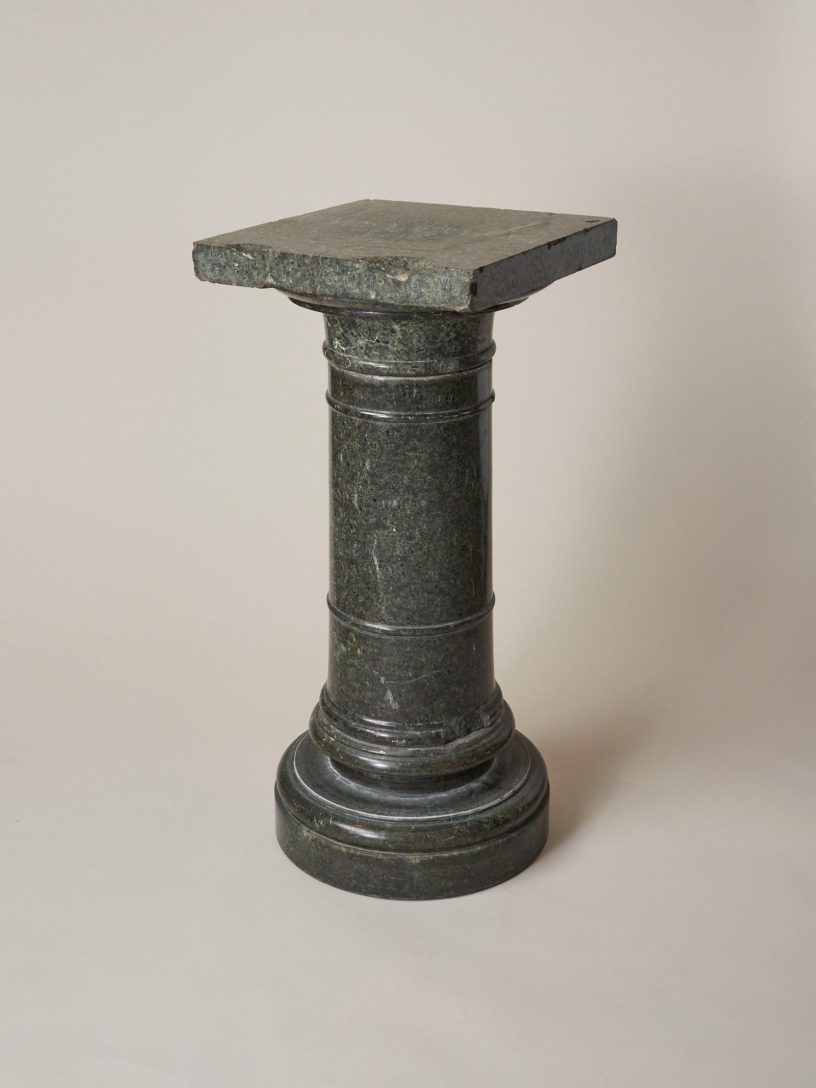 Un piédestal de colonne classique inspiré de l'architecture romaine, le marbre vert apporte une touche d'élégance traditionnelle. Il s'agit d'un élément artistique autonome ou d'une pièce d'exposition complémentaire.