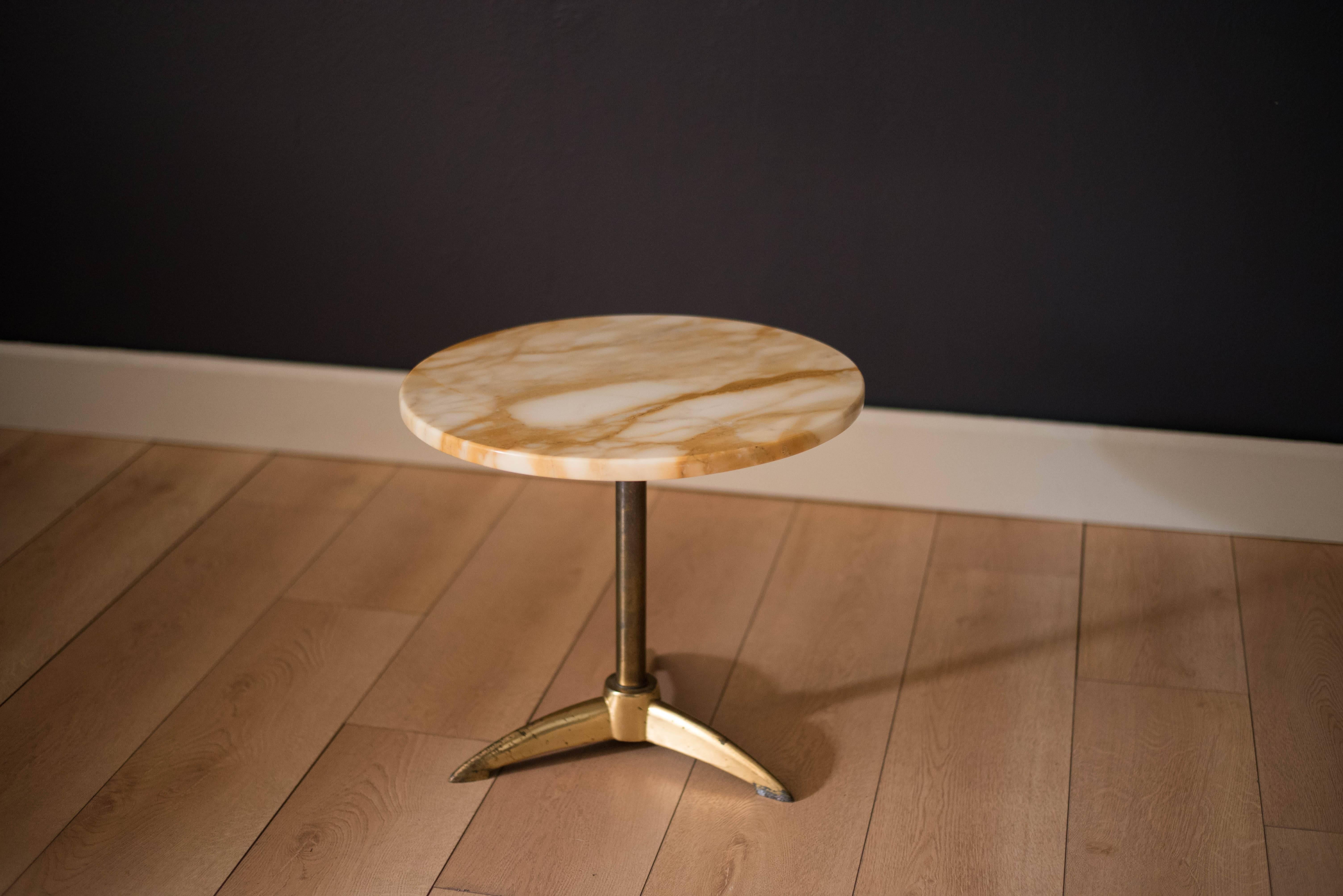 Mid century marble end table with brass pedestal base, circa 1960s. This piece features a round stone top with a white and neutral tone grain pattern made in Italy.