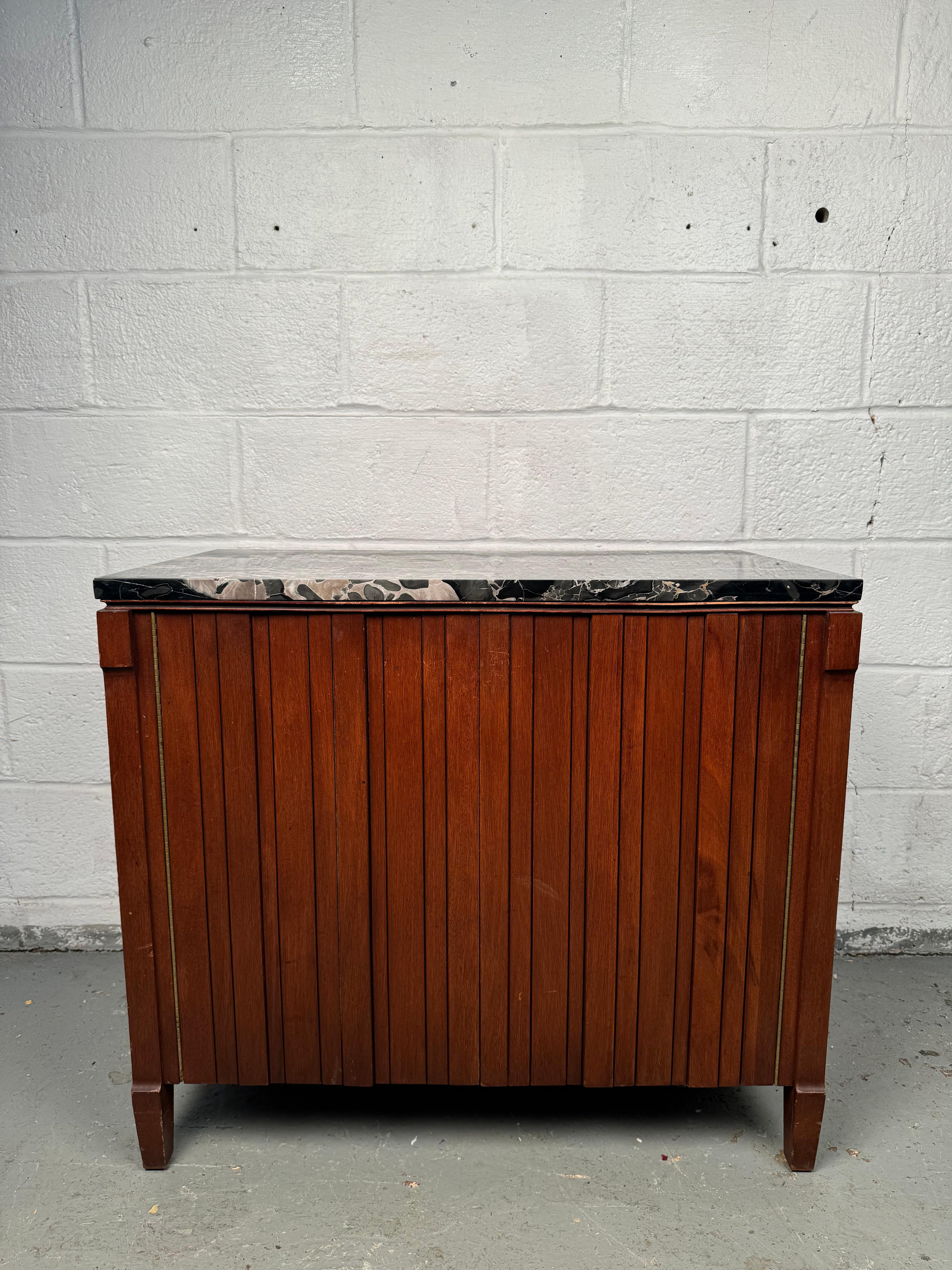 Exquisite Marble Top Cabinet, a rare and refined piece crafted by the renowned John Stuart for Johnson Furniture. This stunning cabinet effortlessly blends classic sophistication with timeless functionality, making it a perfect addition to both