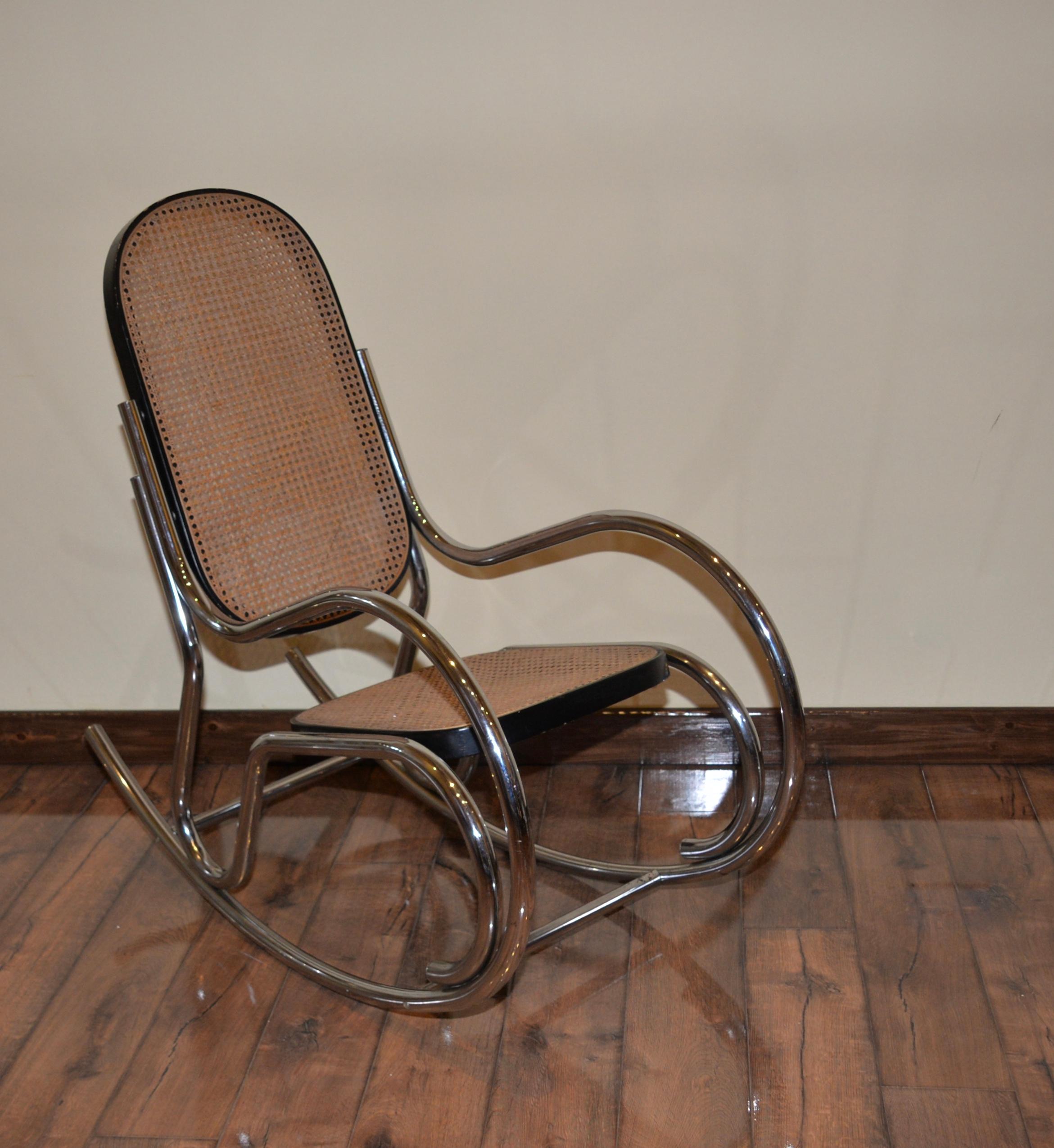 Vintage Marcel Breuer style scrolled rocking chair. A chrome tubular scrolled frame with a black wooden frame and a caned seat and backrest.
 