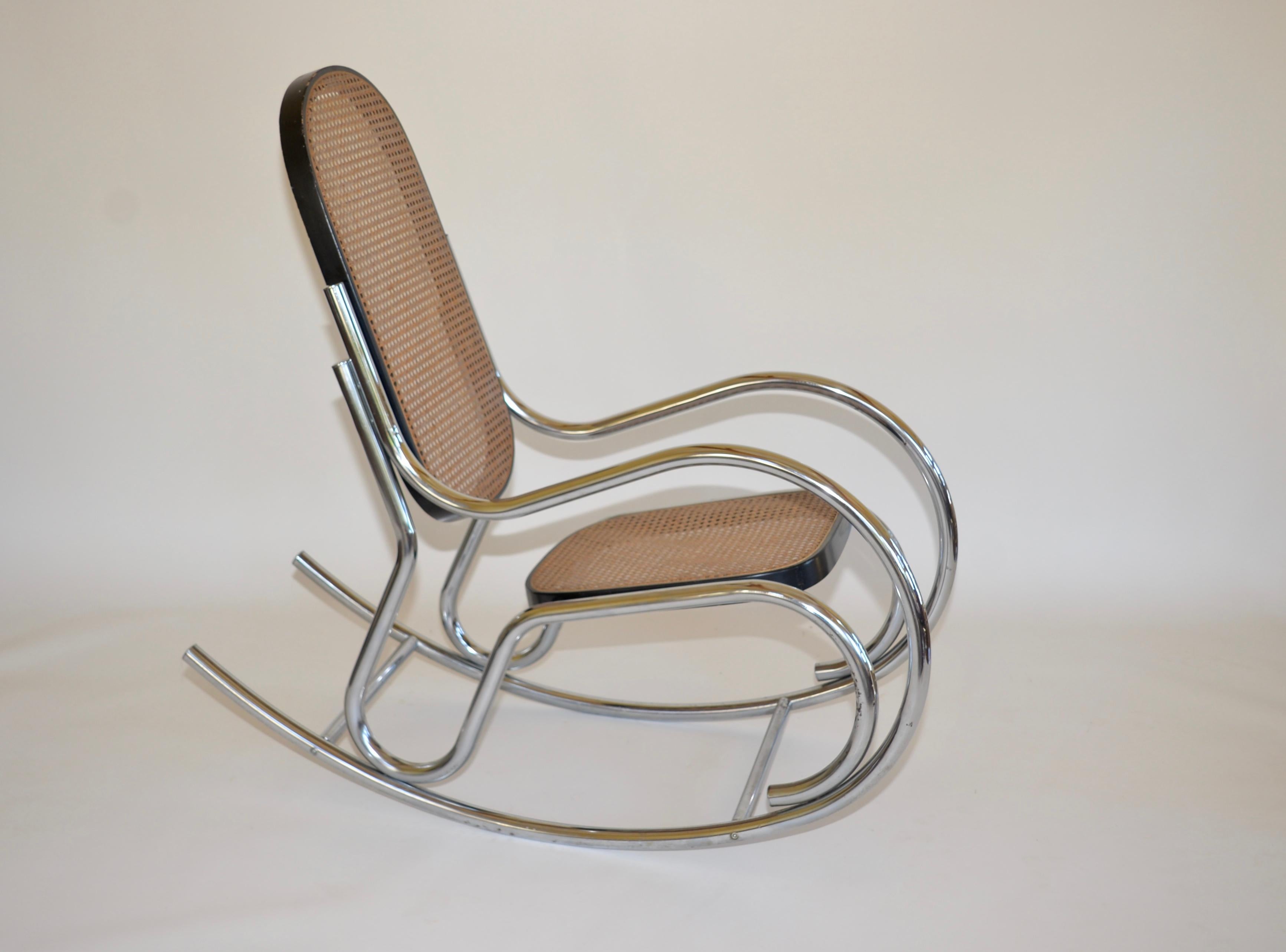 Vintage Marcel Breuer style scrolled rocking chair. A chrome tubular frame with a black wooden frame and a caned seat and backrest.
  