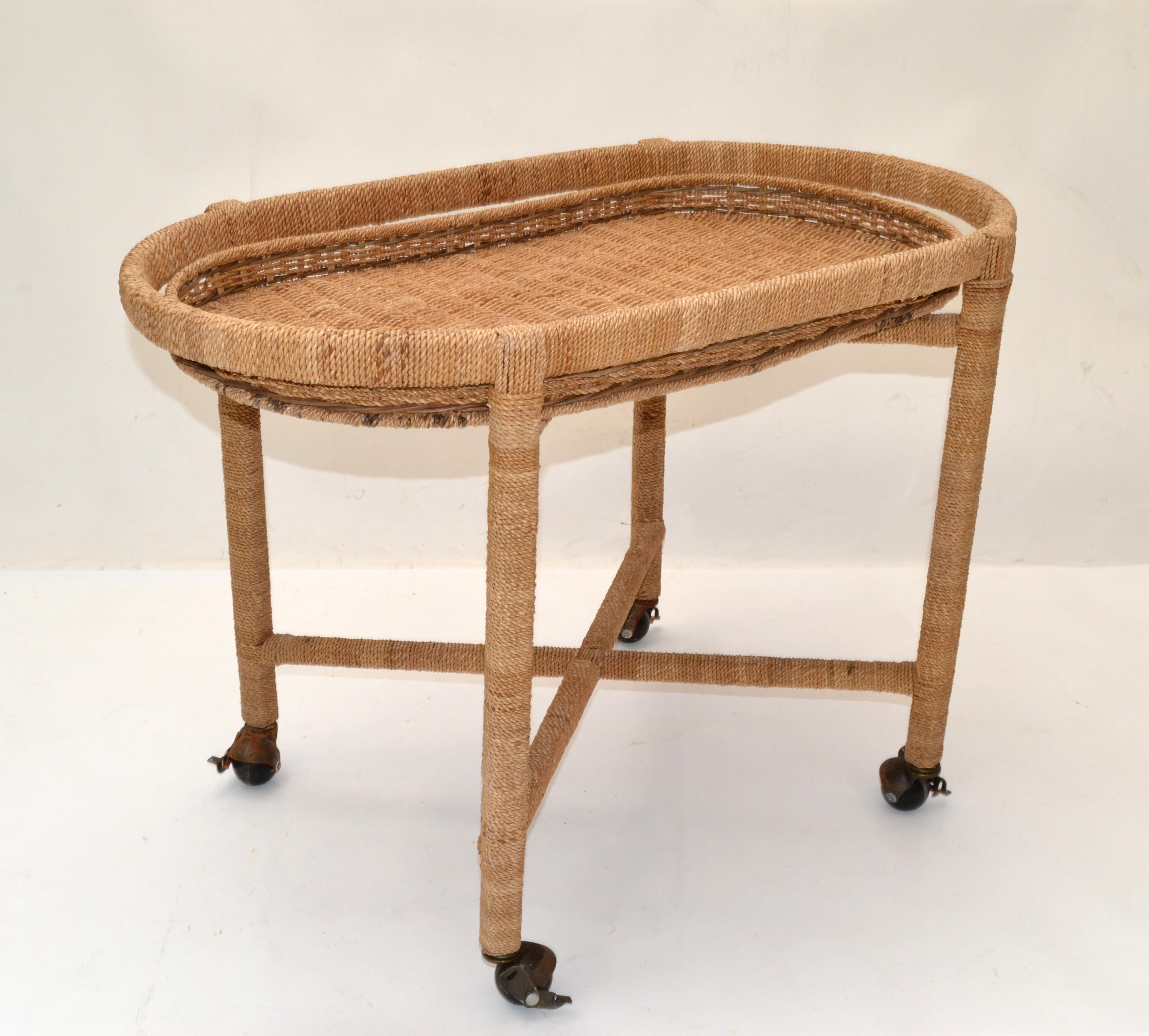 Mid-Century Modern Mario Lopez Torres style rope, wicker, rattan serving trolley, bar cart or tray table on 4 metal casters.
Features a removable handwoven Tray Top and 2 tier Cross Stretcher for support.
Original vintage condition firmly linked
