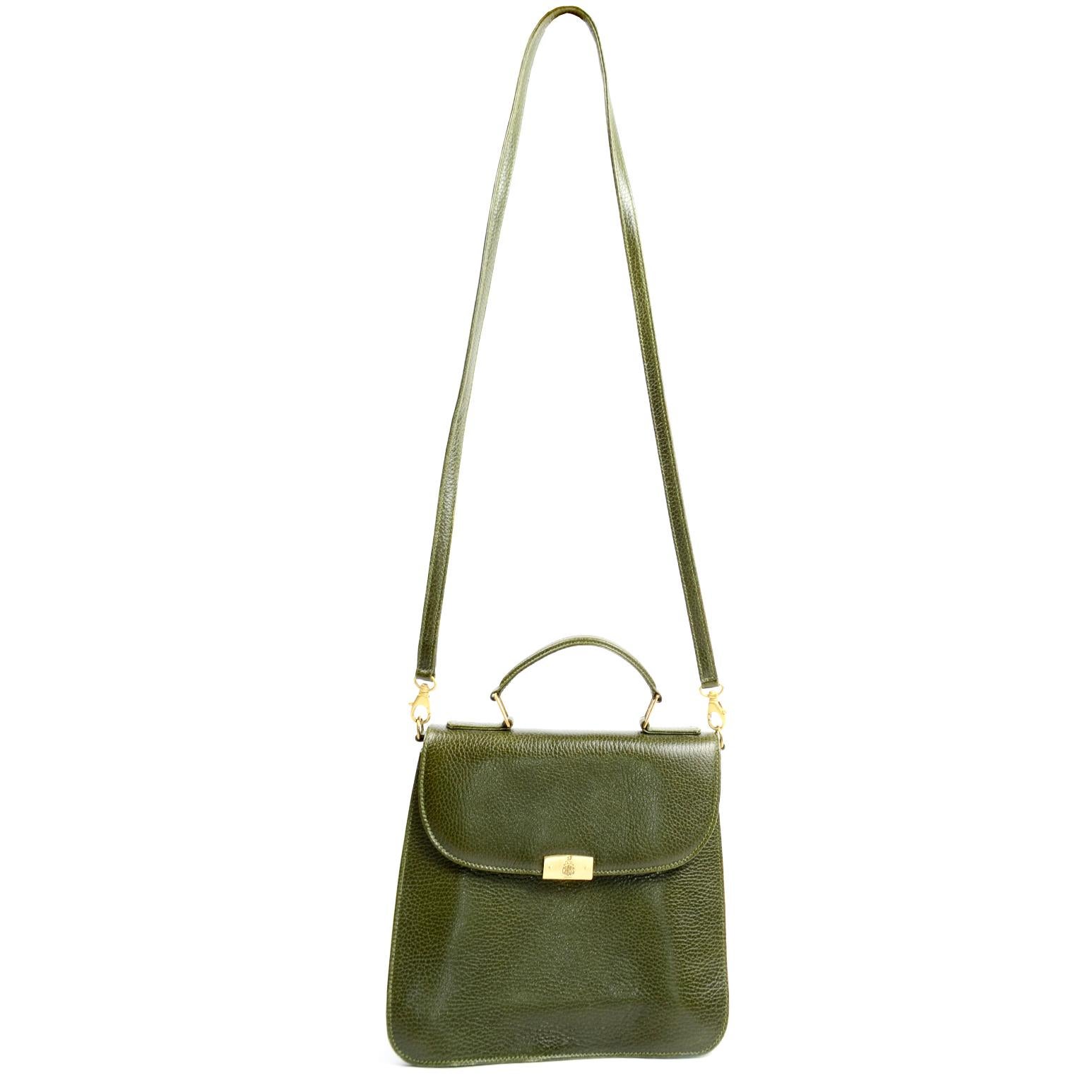 This is a luxe green pebble leather Mark Cross top handle handbag with a removable shoulder strap and matte gold hardware. You can carry this handbag as a satchel or as a cross body or shoulder bag, either way, you will be carrying a bag that was