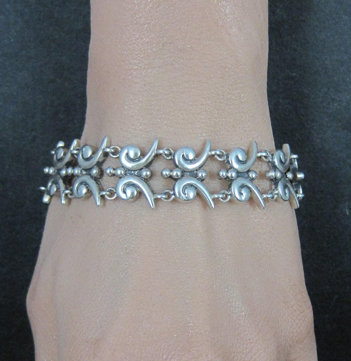This beautiful estate bracelet is sterling silver.
It is a product of Mark Wasserman / M.W. Samara.

Measurements: 11/16 of an inch wide. 7 wearable inches.
Weight: 33.9 grams

Condition: Excellent