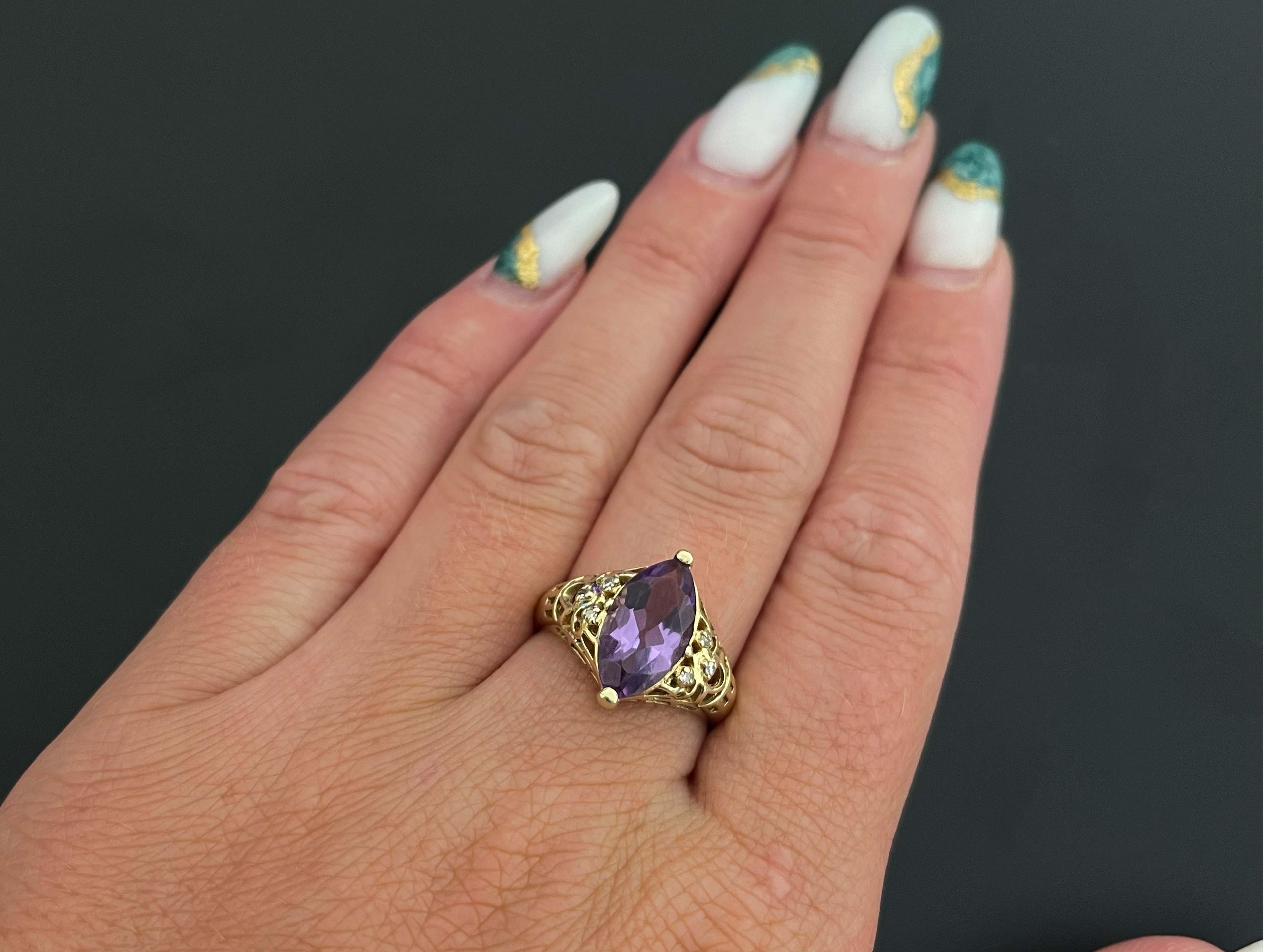 Vintage Marquise Amethyst & Diamond Ring in 14K Yellow Gold. This unique ring features a marquise cut purple Amethyst center gemstone with brilliant faceting. The Amethyst measures approximately 15 mm x 7 mm with an estimated weight of 2.00 carats.