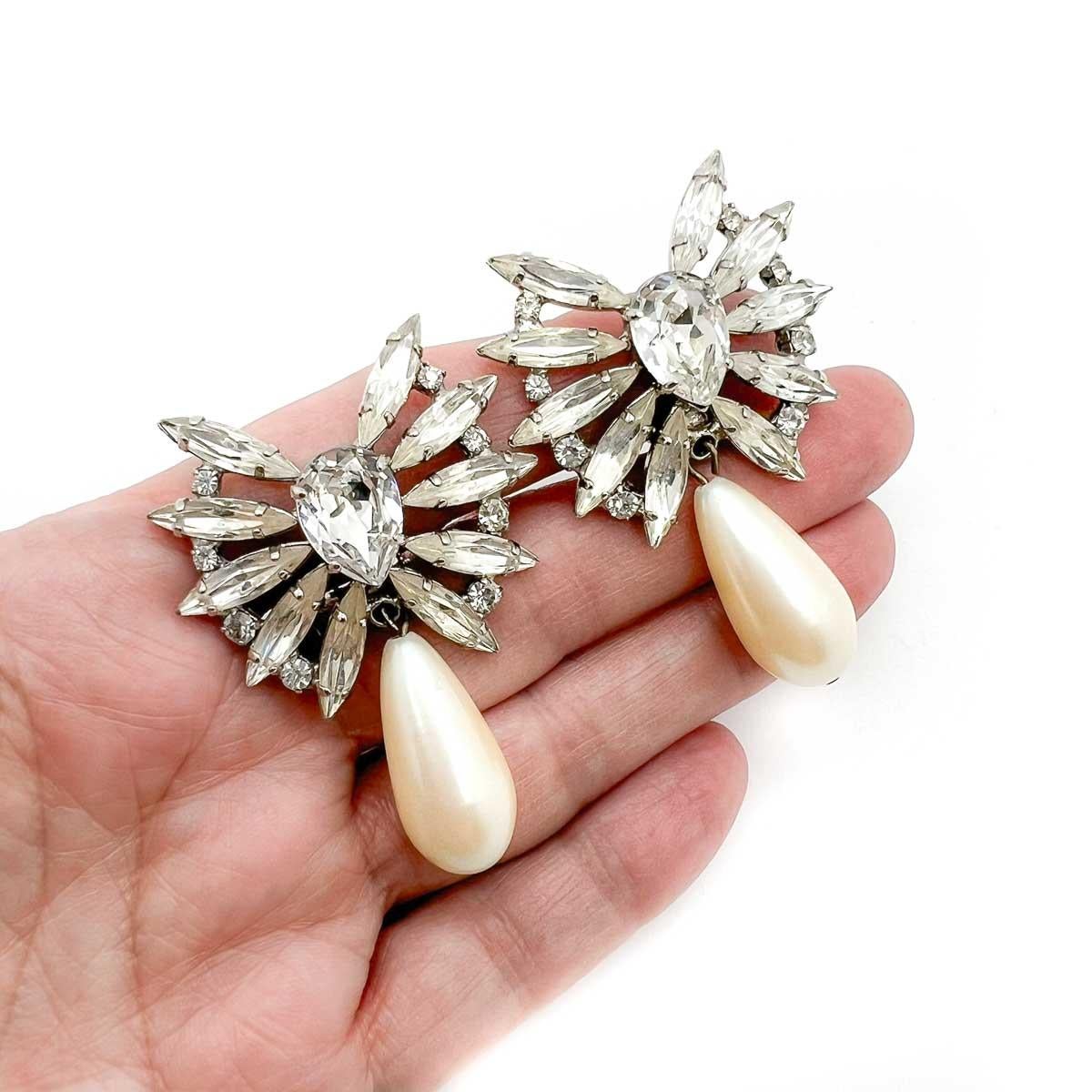 Un paio di orecchini a goccia di perle marquise vintage. Un design senza tempo caratterizzato da una parte superiore a ventaglio di cristalli marquise e dalla perfetta combinazione di una perla a goccia.

Una bellezza non firmata. Un tesoro raro.