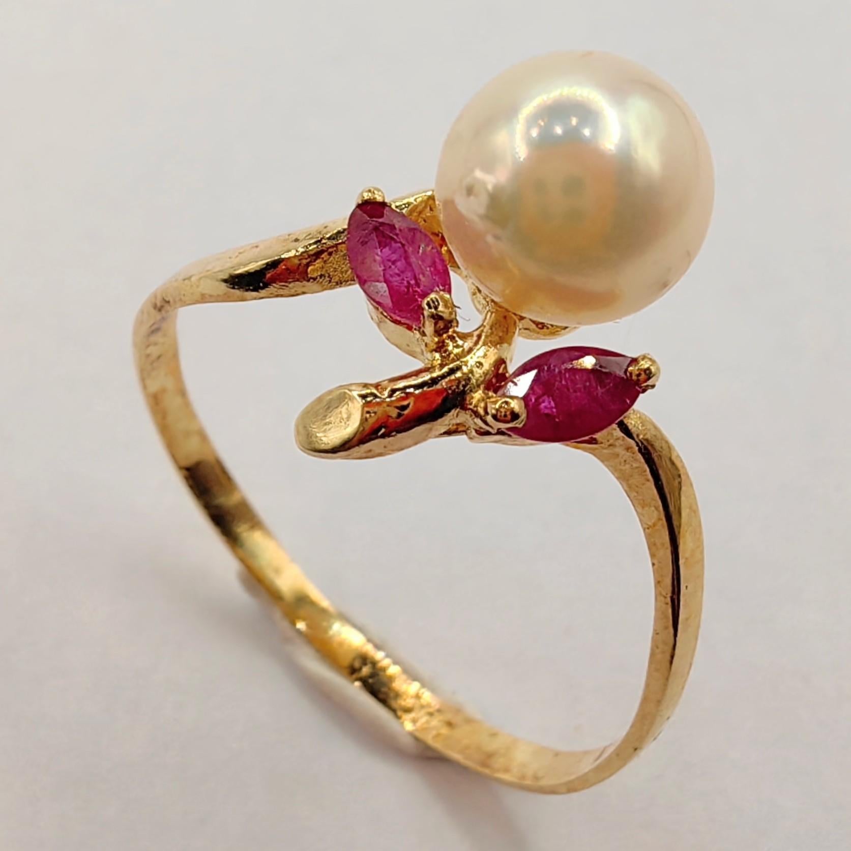 Introducing our Vintage Marquise Cut Rubies & Pearl Ring in 14K Yellow Gold, a timeless piece that combines classic charm with graceful elegance.

At the heart of this exquisite ring lies a lustrous Freshwater Cultured Round Pearl, measuring 6.38mm.
