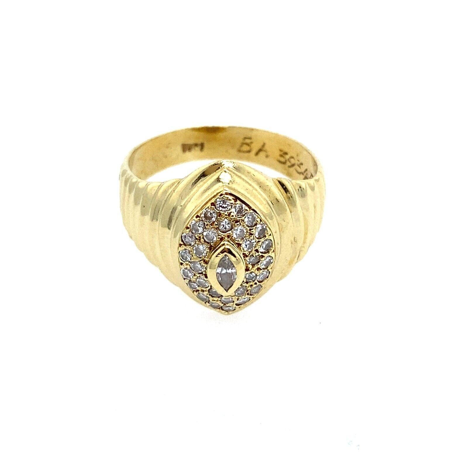 Cette magnifique bague de forme marquise en or jaune et blanc 18ct est une pièce parfaite à porter tous les jours. Le diamant de taille marquise au centre de la bague est entouré de diamants ronds. Il s'agit d'une bague très élégante et