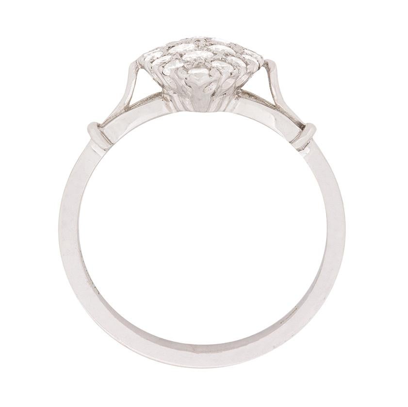 This 1970s era diamond cluster ring is comprised of round brilliant cut diamonds in varying sizes set within a marquise-shaped bezel.

The ring is set in 18 carat white gold, which accentuates impeccable F colour of the diamonds, and the vintage