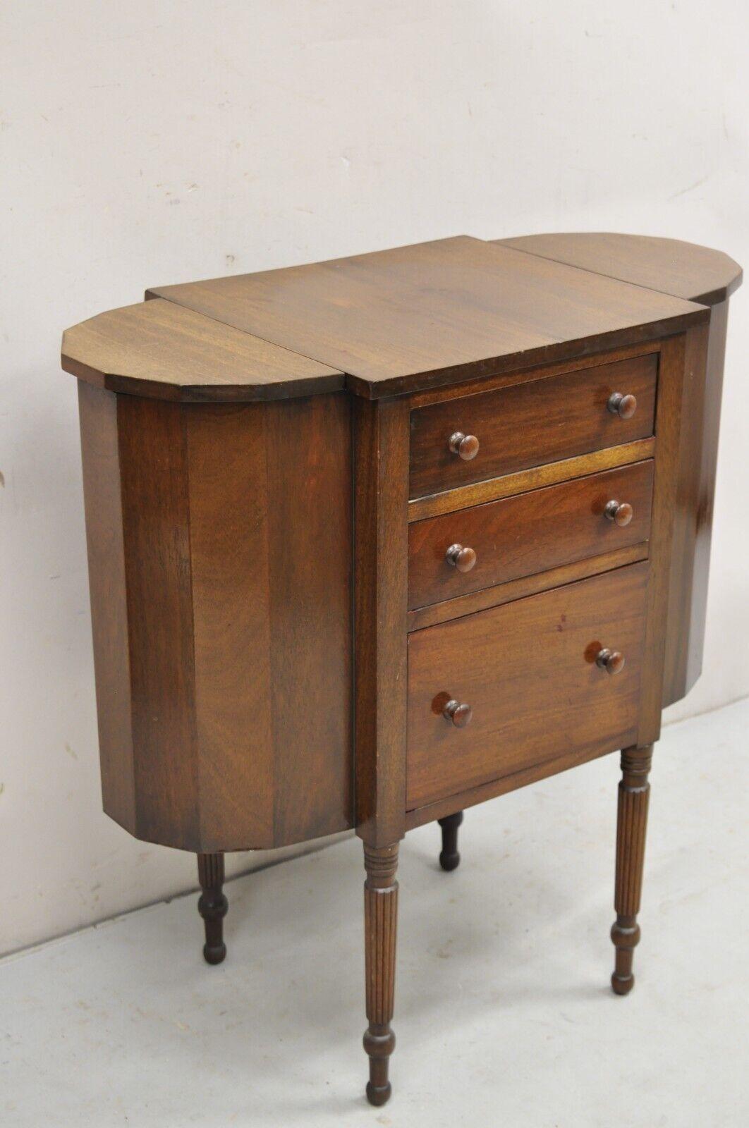 Vintage Martha Washington Colonial Style Mahogany Sewing Stand Side Table Cabinet. Item features solid wood construction, 3 dovetailed drawers, 2 flip tops, removable legs, nice vintage sewing cabinet. Circa Early 20th Century. Measurements: 29