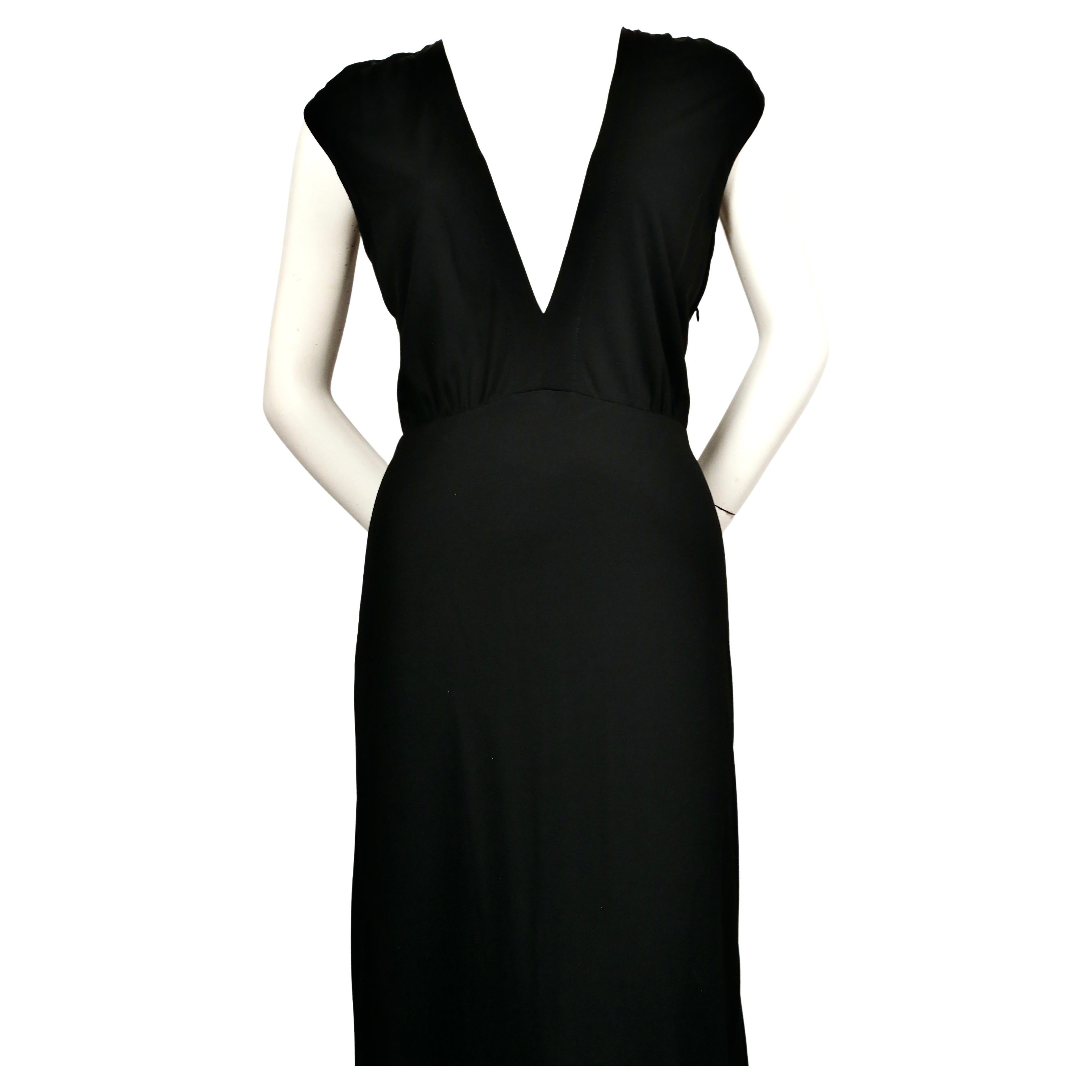 Jet-black jersey '1970's evening dress' designed by Margiela from the 'Replica' line dating to the early 2000’s although an almost identical dress was seen on the spring 1995 runway in white. Deep 'V' neckline and ruching at shoulders. No size is